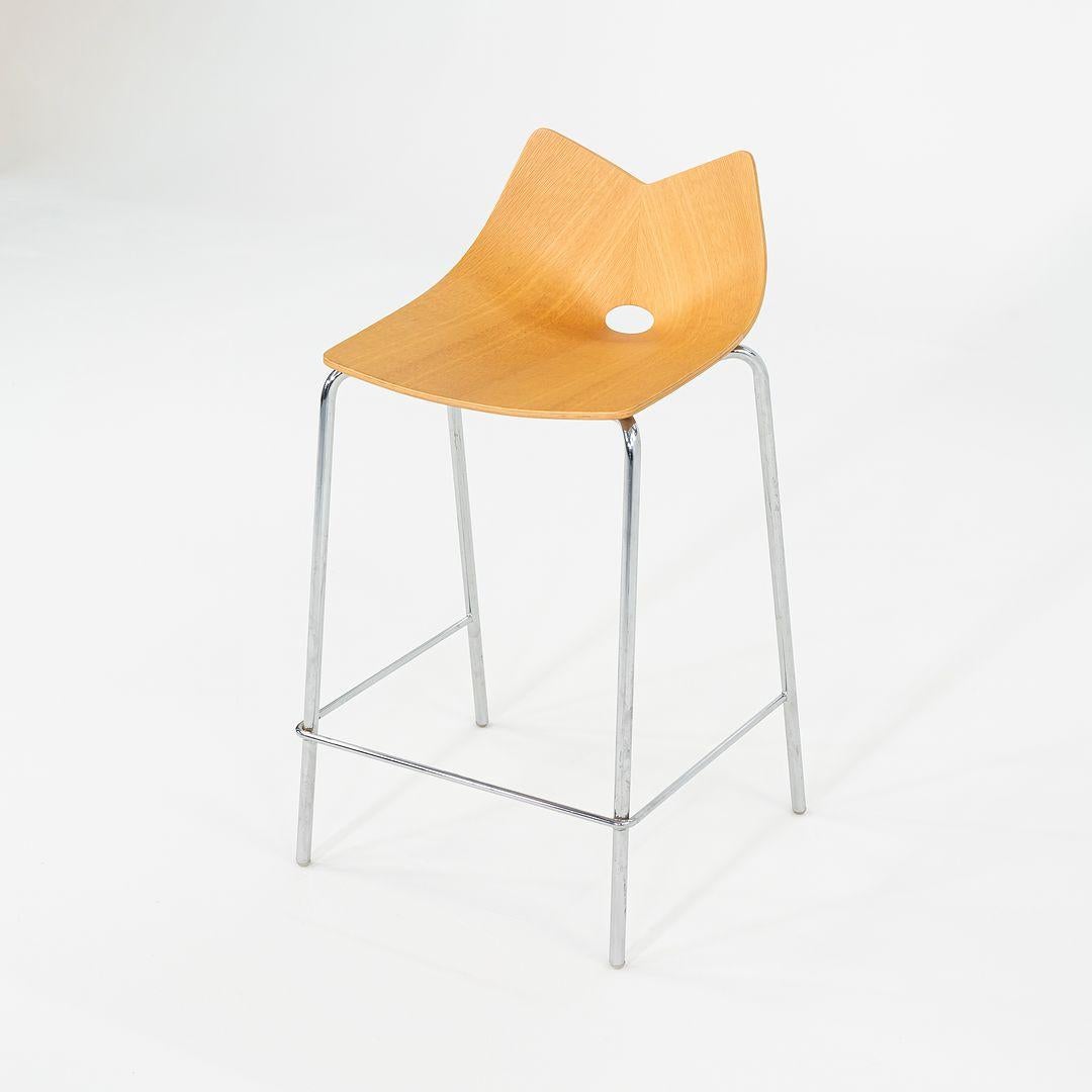 These are Contemporary Oak-Veneered Bent Plywood and Chromed-Steel Counter Stools, designed by Allermuir in ca. 2006. The listed price includes one stool, and we have twelve available for purchase. This unusual design has a retro style, reminiscent