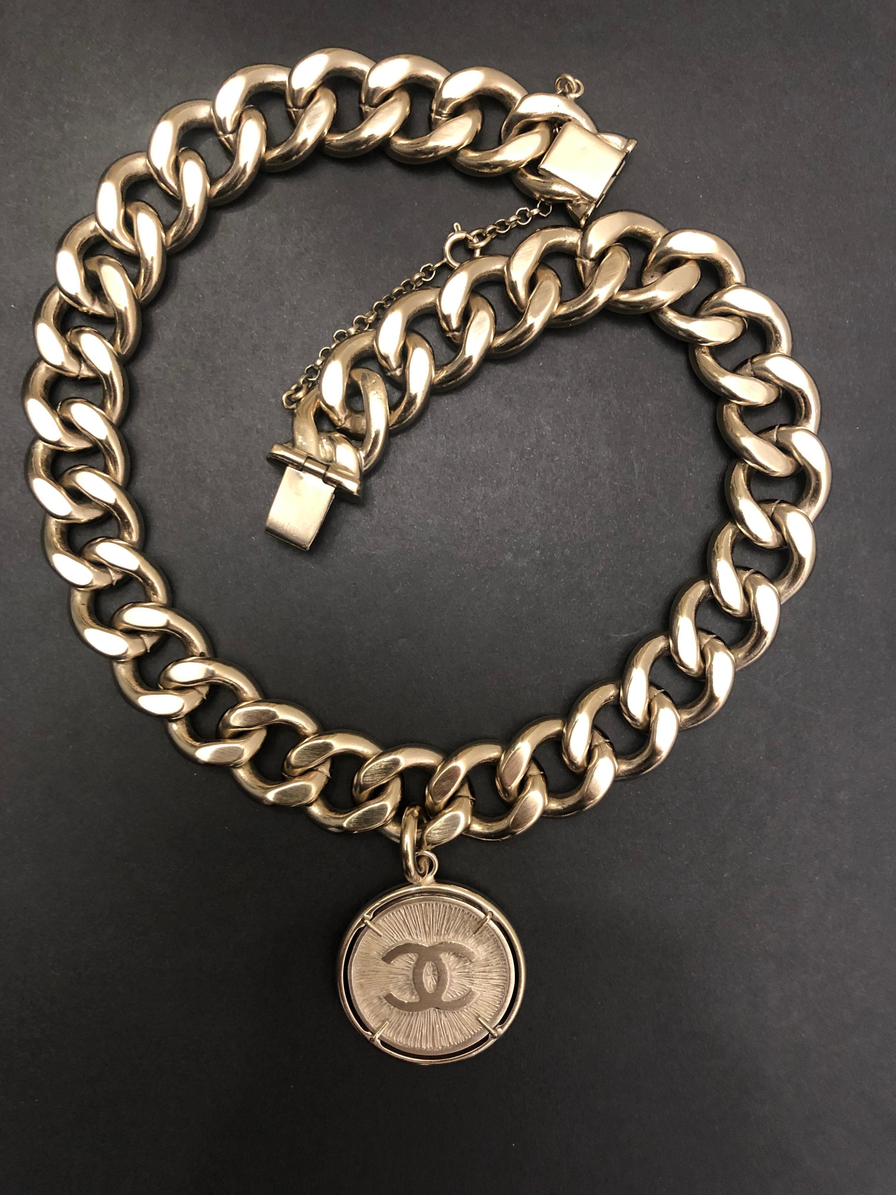 This CHANEL choker chain necklace is crafted of chunky champagne toned chain centered a CC coin charm. The champagne gold color gives it a contemporary look that suits both sexes. The length measures approximately 41 cm. Stamped CHANEL 06P made in