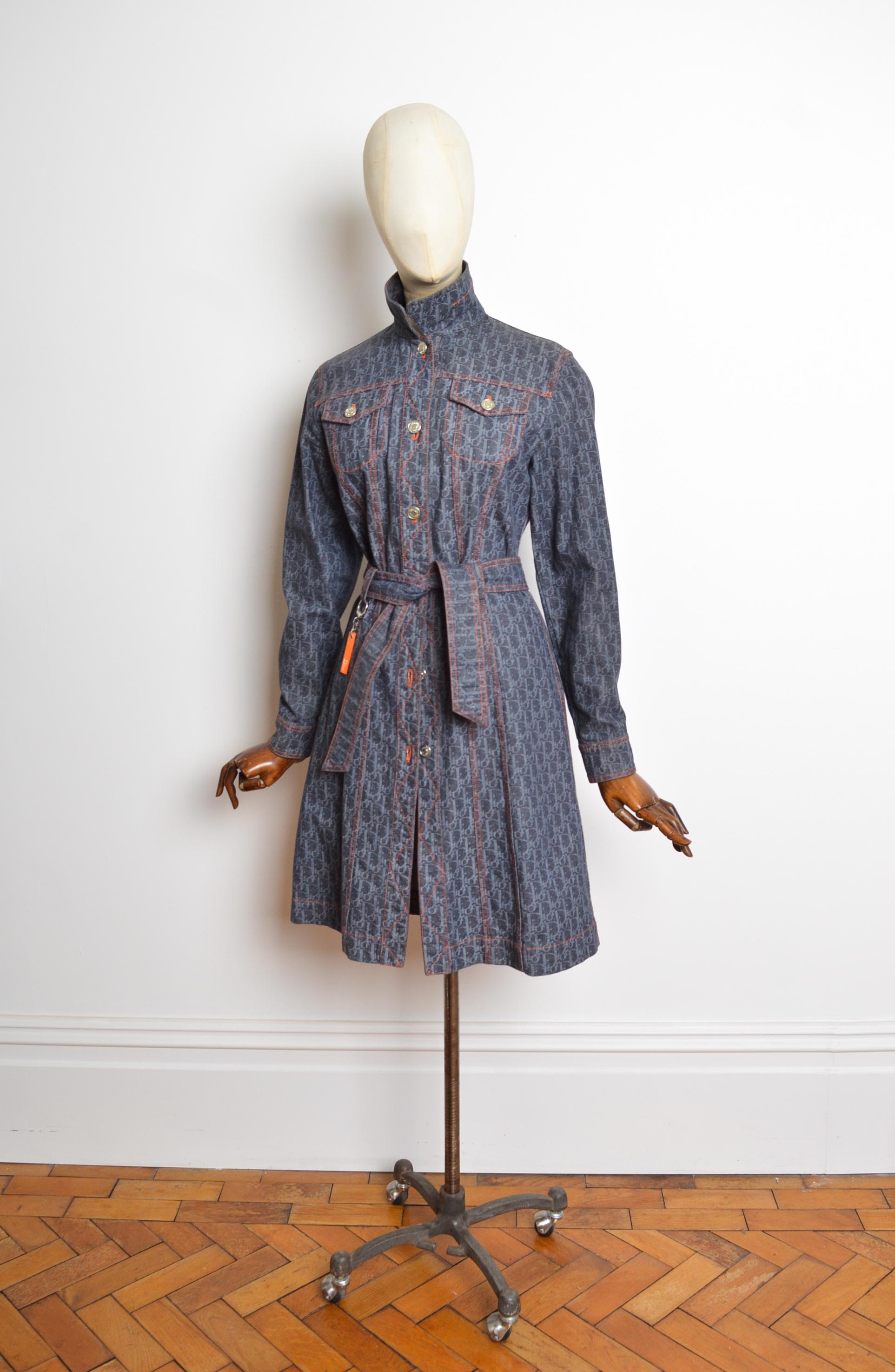 An iconic, Vintage denim jacket by John Galliano for Christian Dior’s Spring 2006 'Remove before flight' capsule collection. This fully monogrammed DIOR belted trotter Jacket features contrast orange stitch, detachable decorative Jelly Tab, chrome