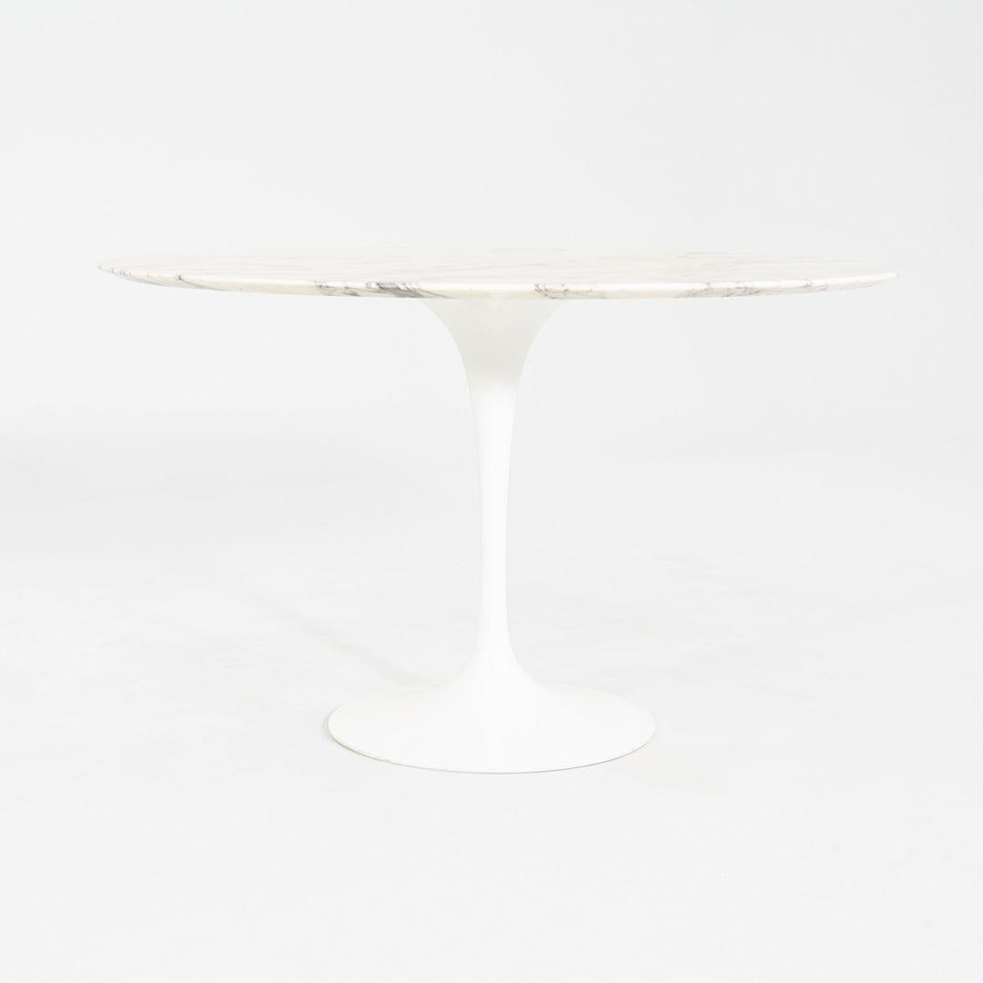 This is a Saarinen Tulip Dining Table, originally designed in 1956 by Eero Saarinen for Knoll. This particular piece was produced in the USA in 2006. The base is formed of molded cast-aluminum which is coated in a white finish with an arabescato