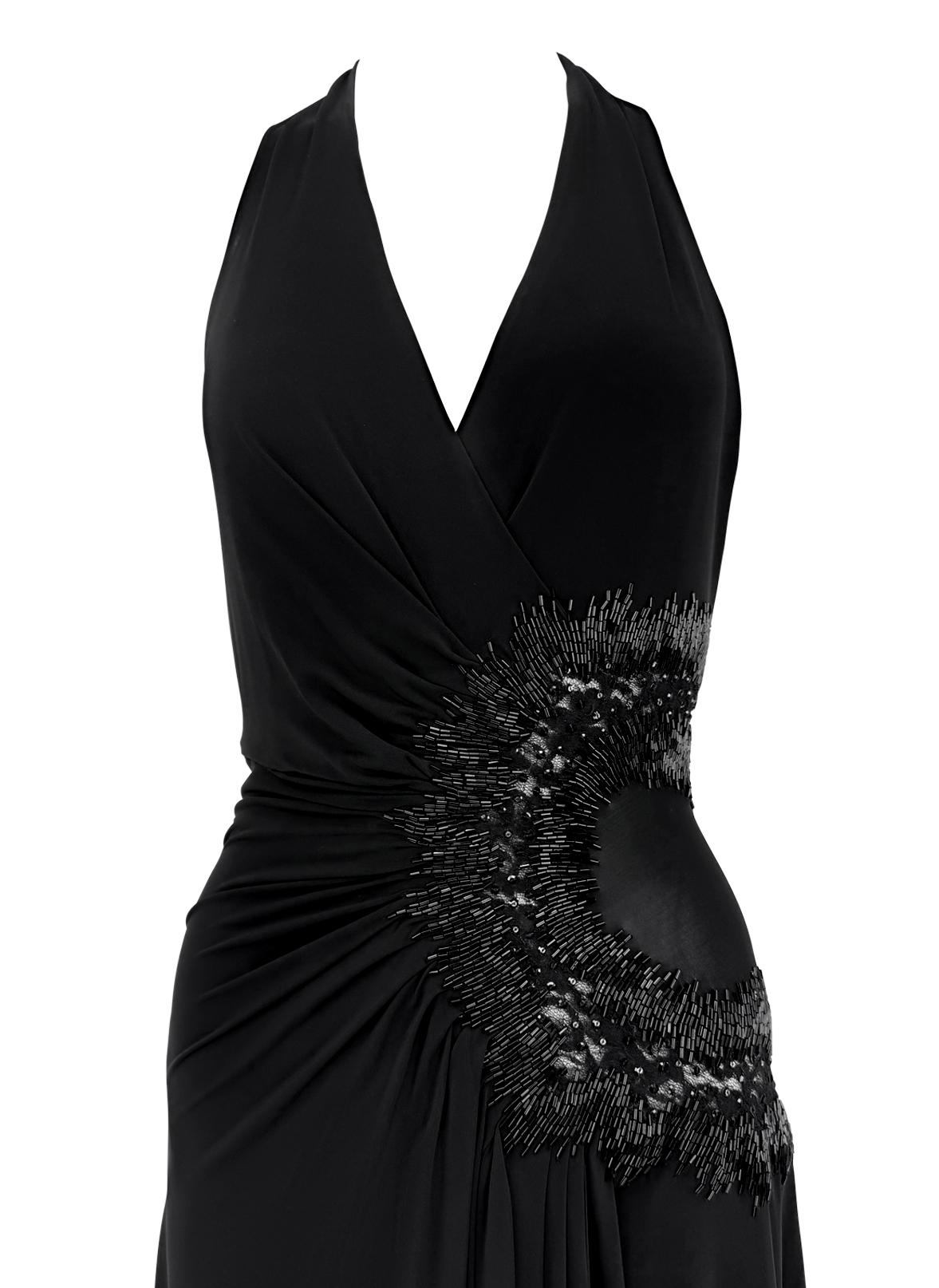 Dalla collezione 2006 di Roberto Cavalli, questo abito nero semitrasparente con scollatura profonda e schiena asimmetrica, con finiture dorate sul collo. Il pizzo nero trasparente e la viscosa semitrasparente sono impreziositi da strass e perline