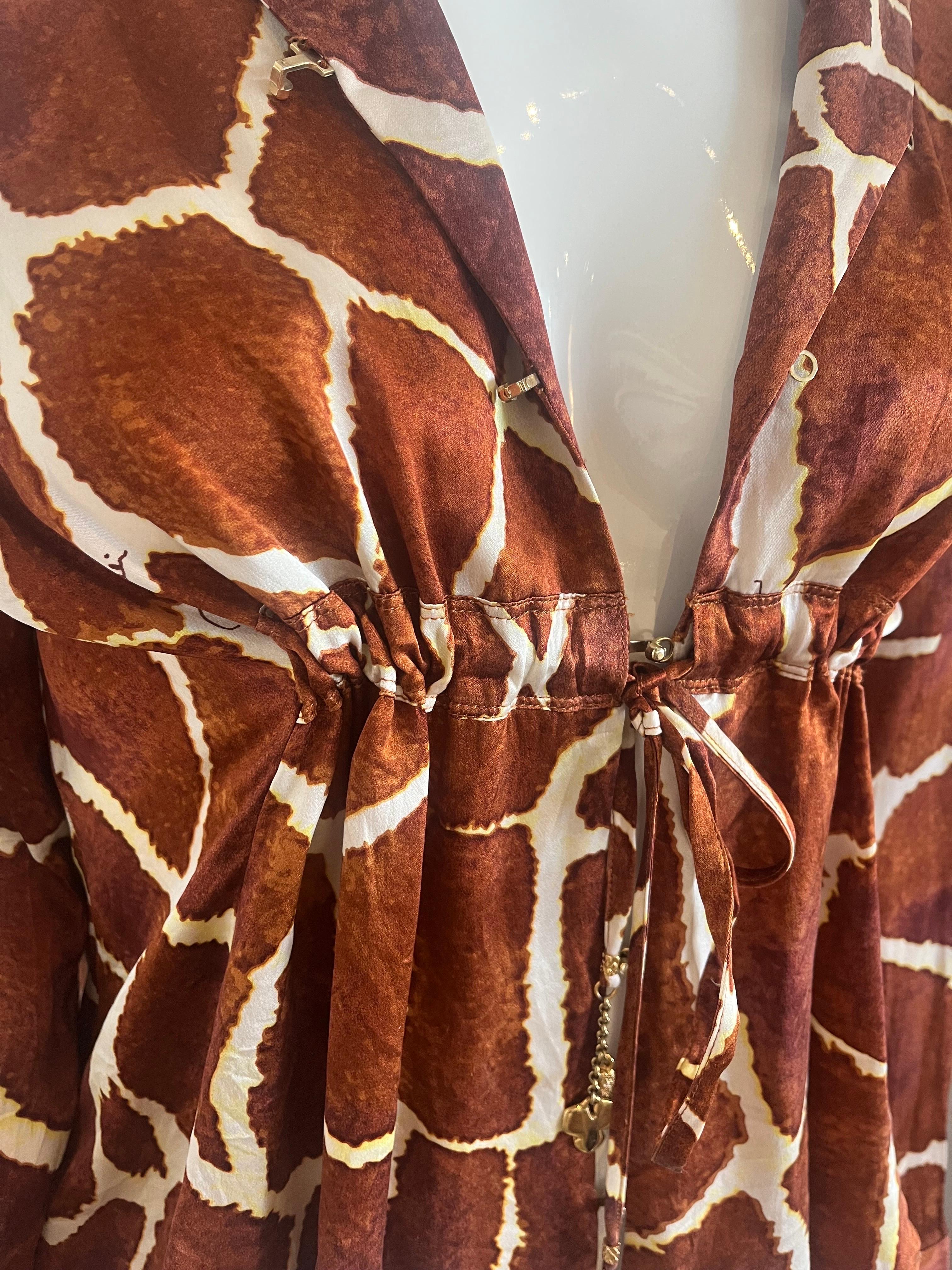 Issu de la collection Roberto Cavalli 2006, ce top en soie imprimé girafe se ferme par des cordons sous la poitrine et par de lourdes fermetures métalliques à crochets qui laissent un peu d'espace au milieu.  Le col tombe pour un look de plage en V