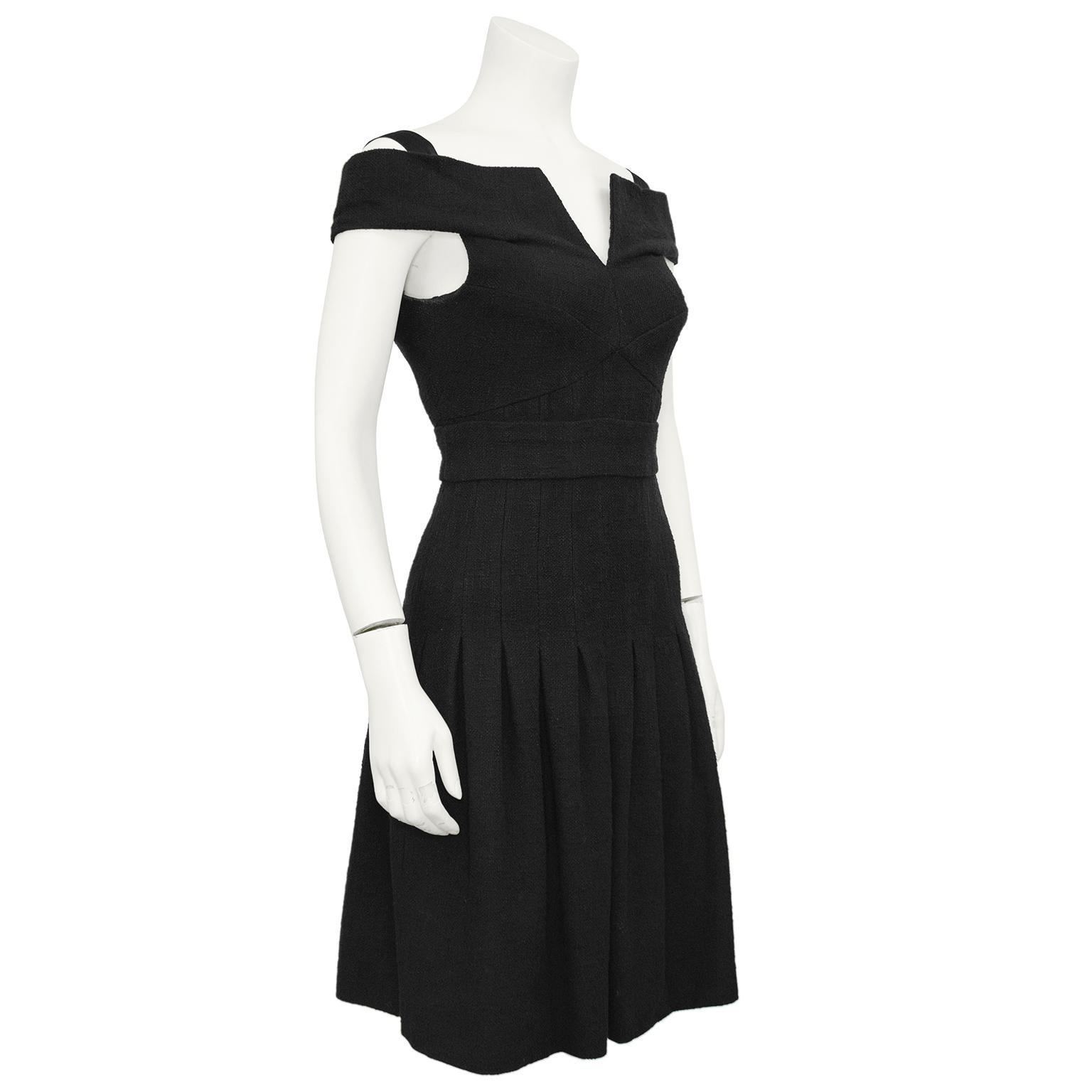 Timeless Chanel bouclé off the shoulder fitted bodice dress from the 2007 Cruise collection. V-neck opening enhanced by a similar V opening at the back above the zipper. Chanel black enamel CC logo buttons give the faux shawl collar a finished look.