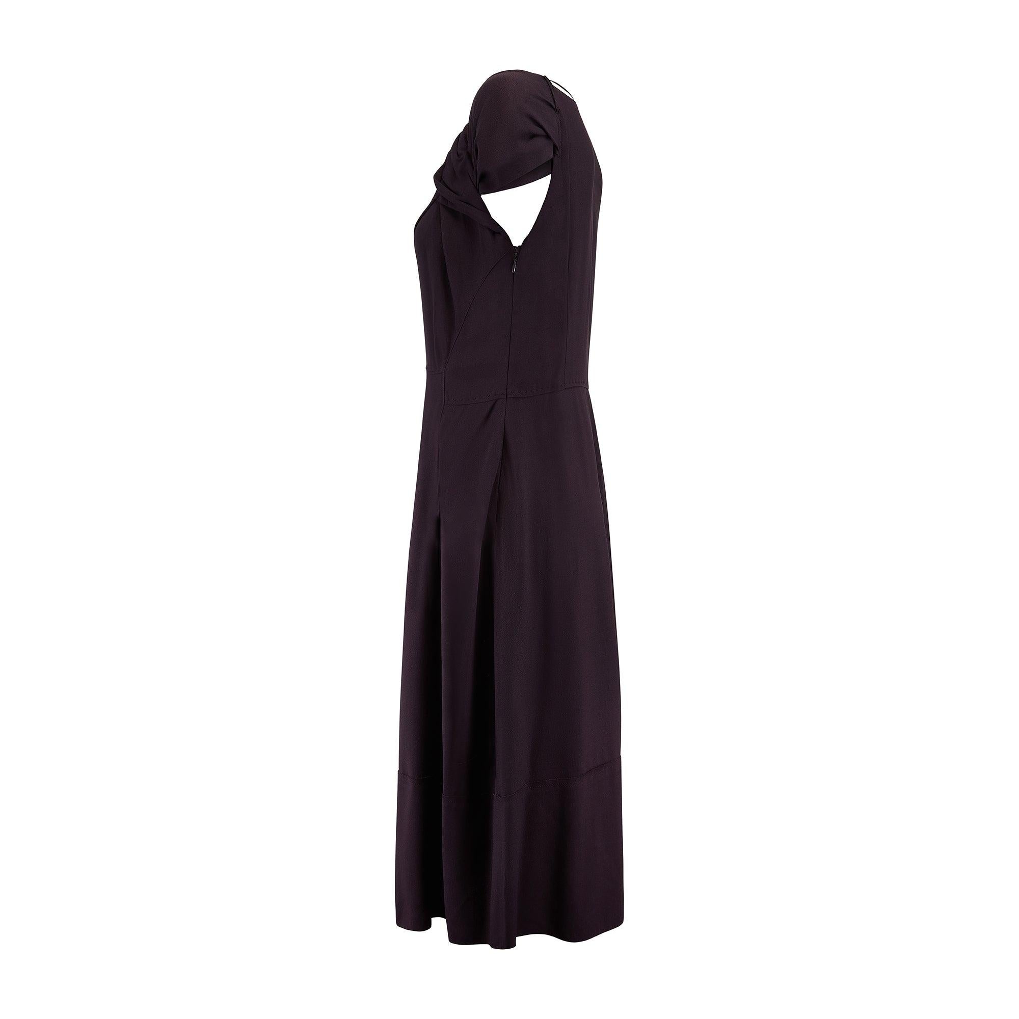 This elegant Prada gown displays all the elevated, feminine trademarks that have become a part of Miuccia Prada’s signature style. Designed in 2007, it is tailored from smooth crepe in a rich, deep plum colourway. Tailored to a 1940s tea-dress