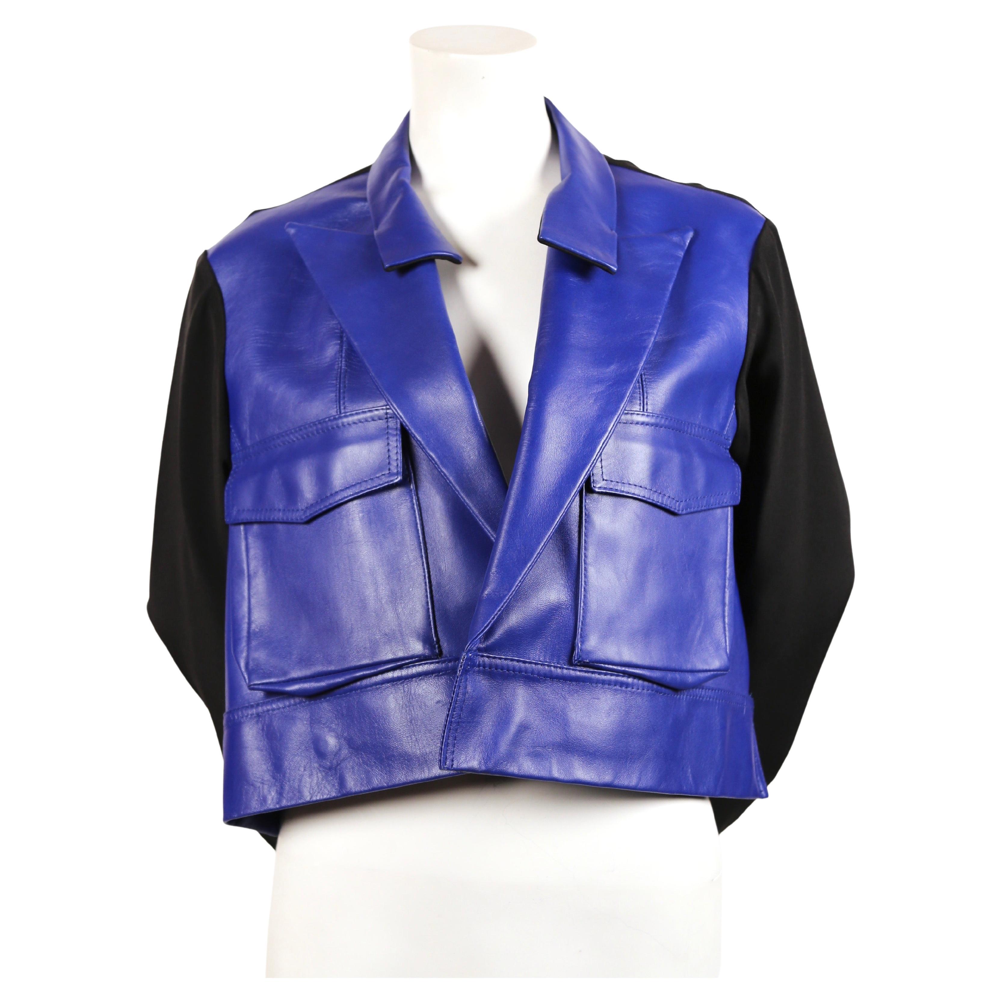 Vivid-blue, leather jacket with black silk sleeves and forced forward closure from Yohji Yamamoto exactly as seen on the runway fall of 2007. Looks great worn open as well. Labeled a Japanese size 2. Approximate measurements: shoulders 16