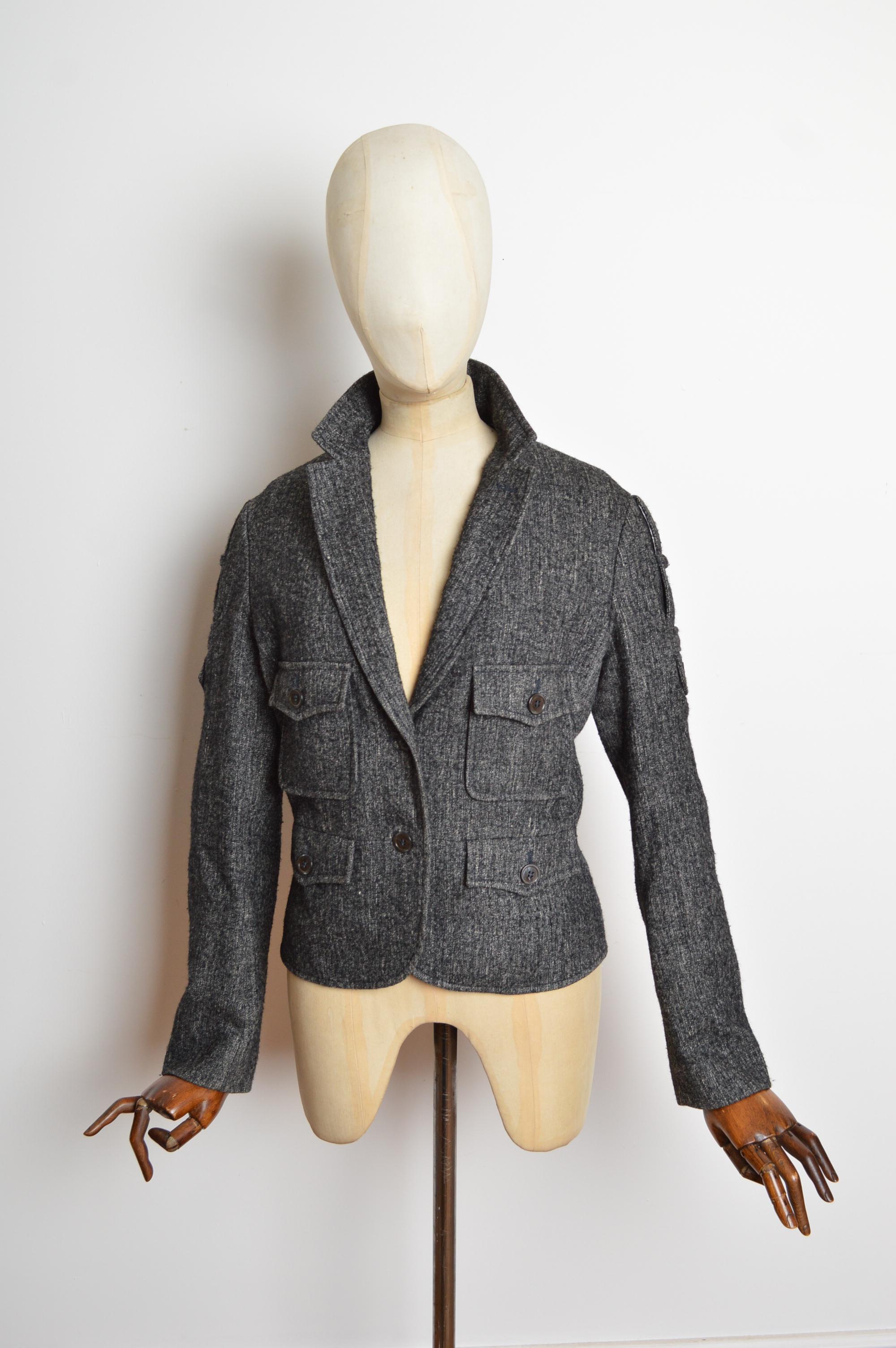 A 2007 mottled wool blazer by Stefano Pilati for Yves Saint Laurent Rive Gauche. Crafted from a soft, charcoal grey wool. Featuring 4 front pockets, two button closure and epaulette detailing on the arms. 
Measurements are provided in inches