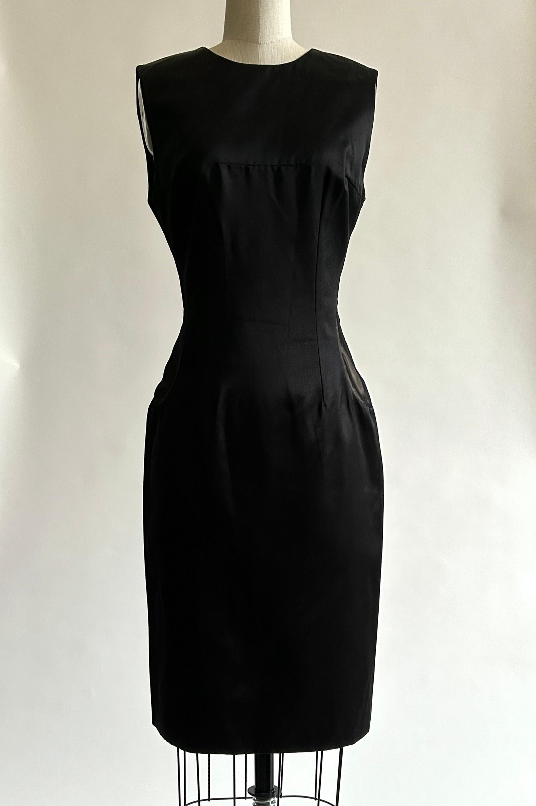 Robe ajustée en soie noire d'Alexander McQueen, avec empiècements en forme de goutte d'eau en maille transparente sur les côtés et doublure nude en dessous. Les panneaux inattendus ajoutent juste ce qu'il faut d'audace à une robe noire classique !
