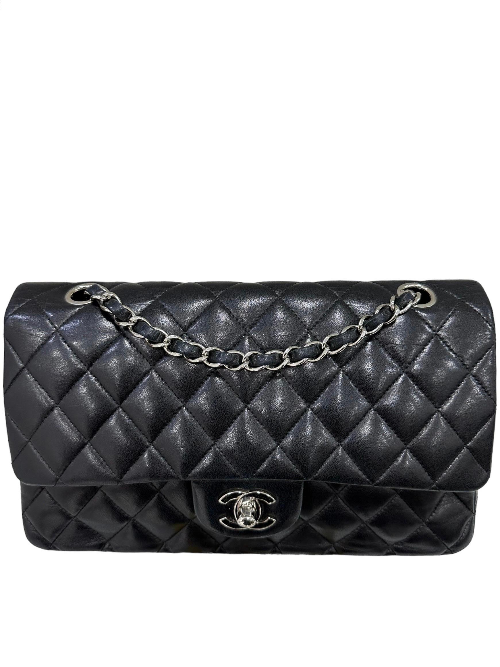 Chanel signed bag, model 2.55, made of black smooth leather with silver hardware. Equipped with a flap with CC twist lock, internally equipped with an additional flap with button closure. Equipped with a braided leather and chain shoulder strap, to