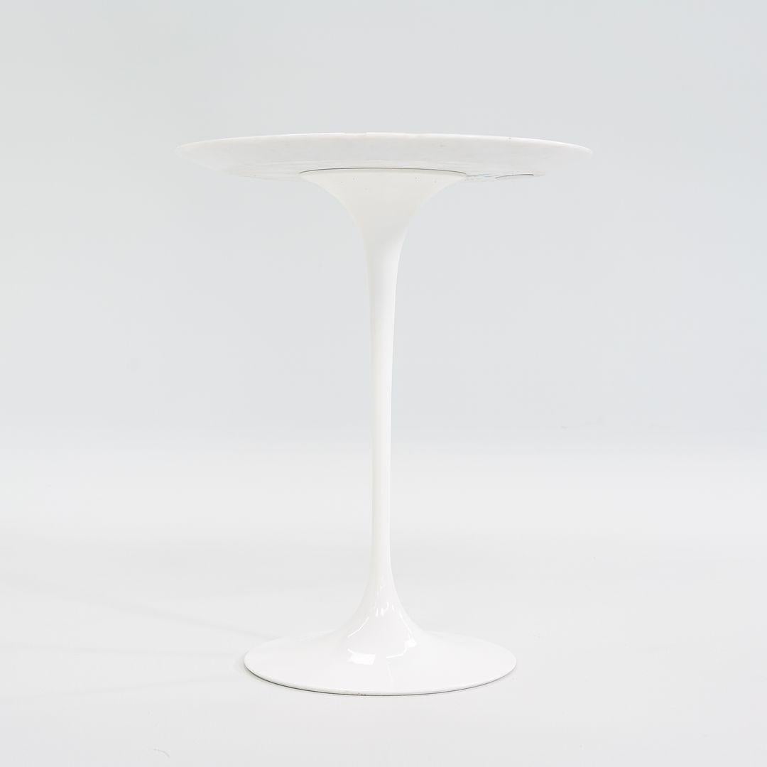 This is a Tulip Pedestal Side Table, Model 16OTR, initially designed in 1956 by Eero Saarinen for Knoll. This particular piece was produced in Italy in 2008. The base is formed of molded cast-aluminum which is powder-coated in a white satin finish.