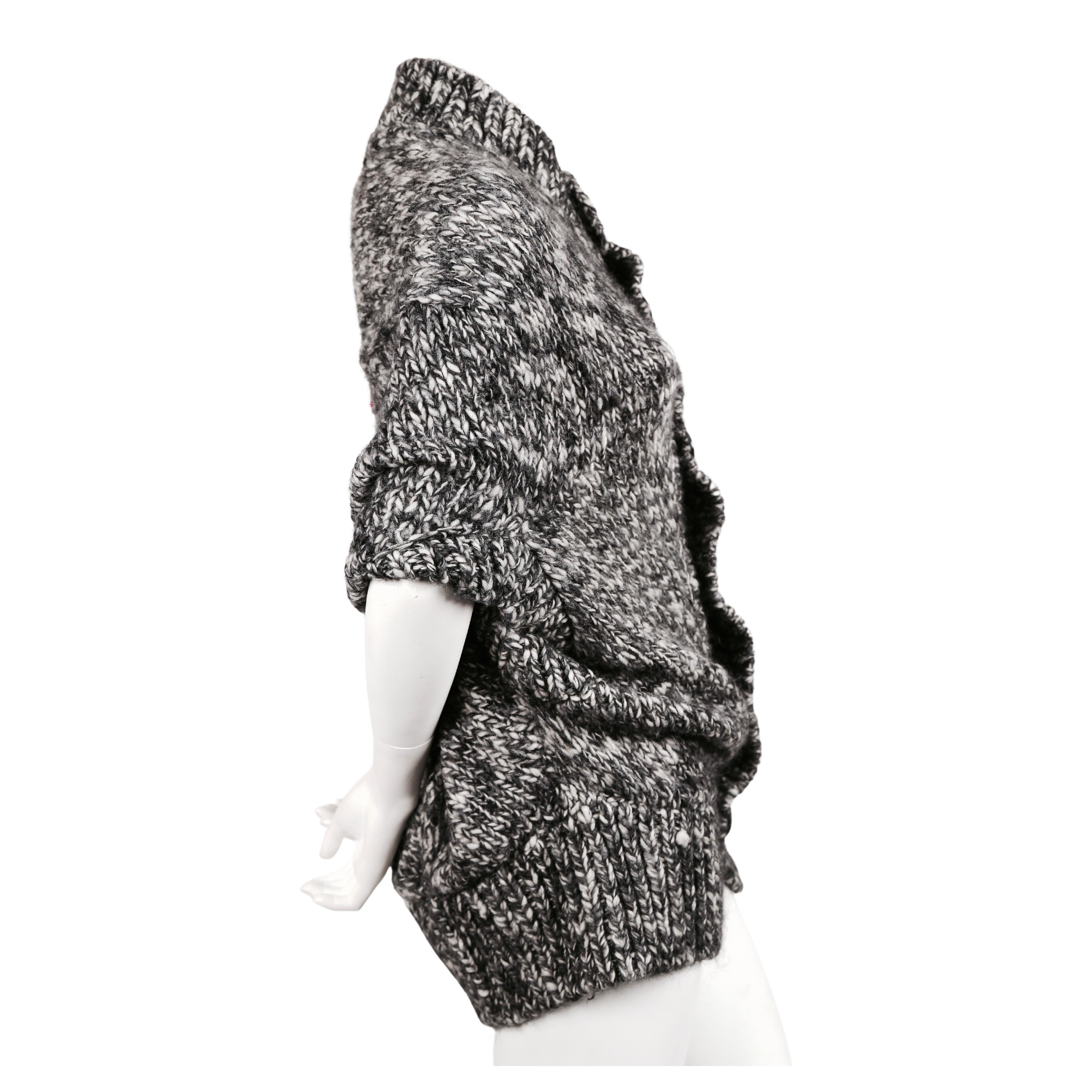 Very soft, grey marled knit poncho sweater with black button front from Junya Watanabe by Comme Des Garcons dating to fall of 2008. Looks great layered over a button up shirt. Labeled a size 'S'. Approximate measurements: bust is flexible, waistband