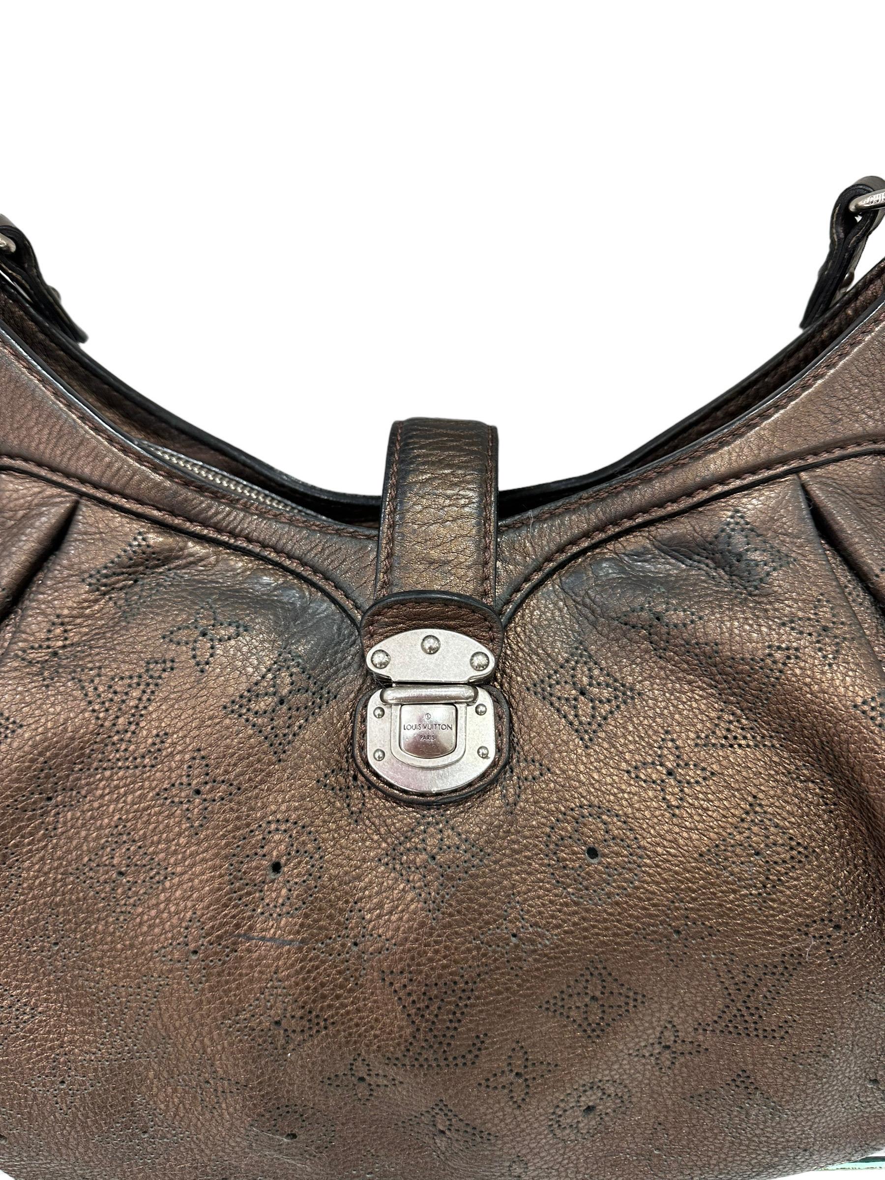 Louis Vuitton signed bag, Mahina model, size XS, made of brown leather with perforated Monogram and silver hardware. Equipped with a central interlocking closure. Equipped with an adjustable shoulder strap to wear it comfortably on the shoulder and