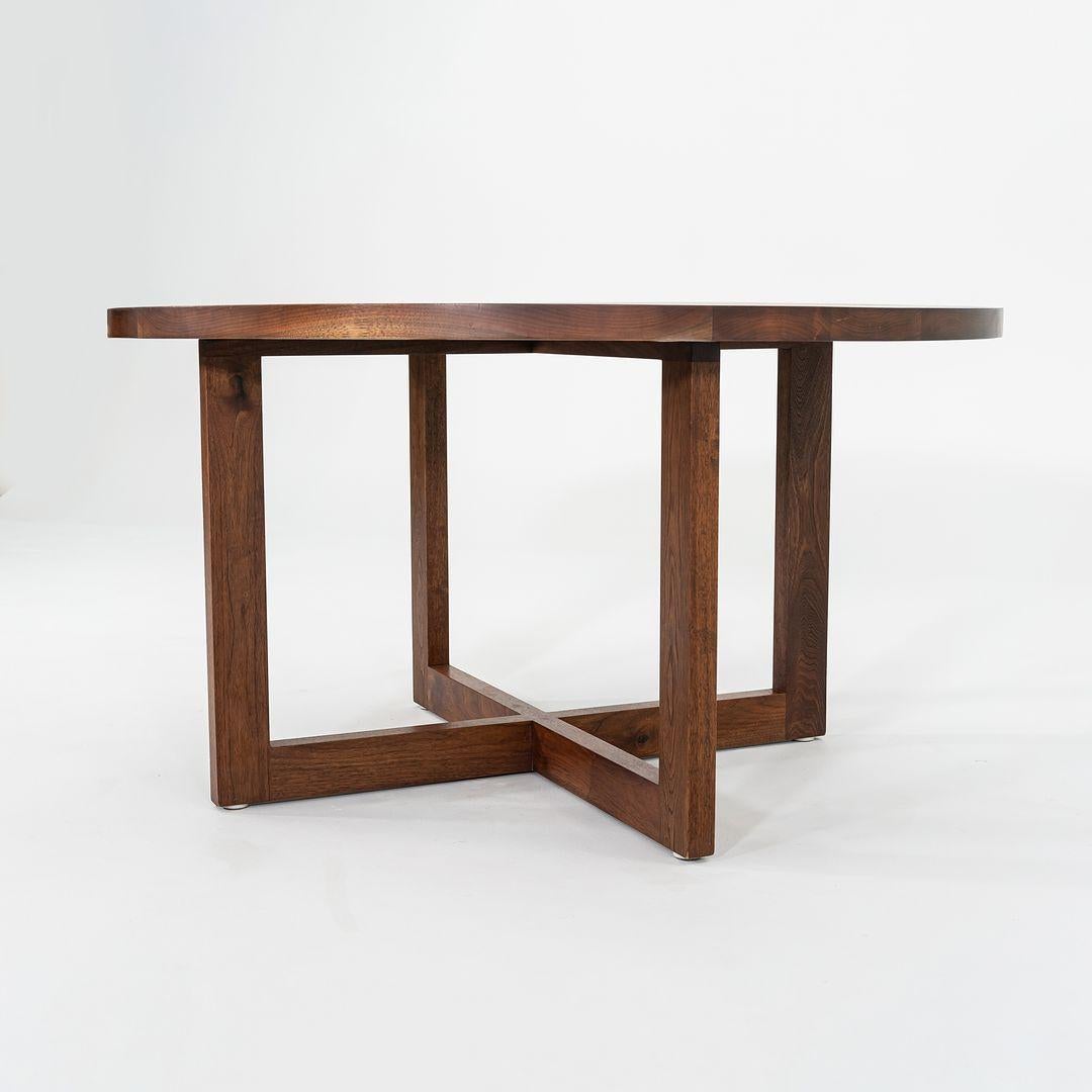 Questo è un tavolo da pranzo rotondo Tobin, progettato da Tyler Hays per BBDW C. 2007. Il pezzo è composto da lastre di noce nero americano massiccio, con una finitura a olio applicata. Gli spessi pezzi di legno sono stati selezionati con cura per