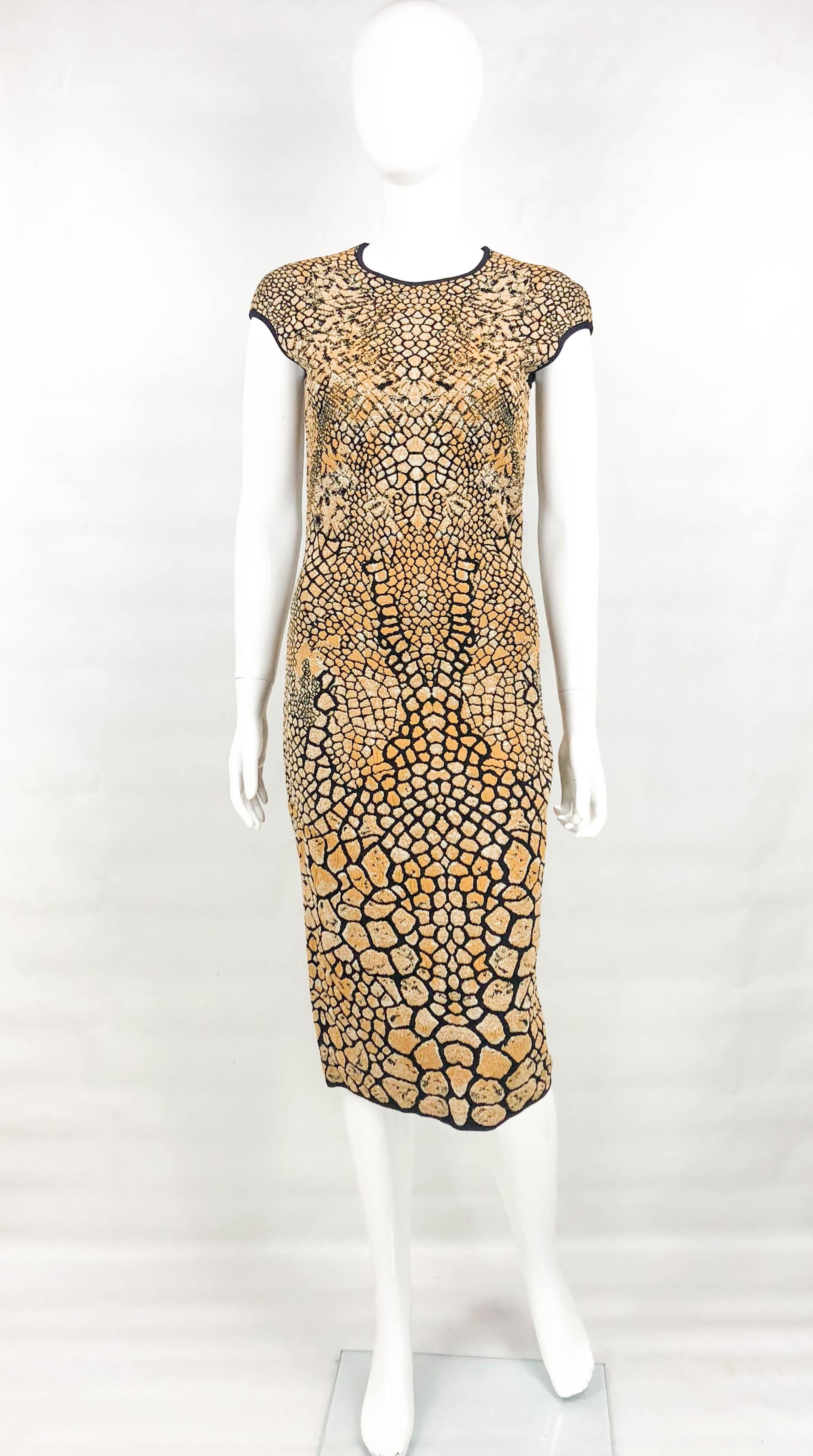 Alexander McQueen Stretch Knit Golden and Black Dress. This beautiful midi dress by Alexander McQueen dates back from 2009. Made in a stretch knitted fabric in accents of golden and black, it features a pattern inspired by bees. It is figure hugging