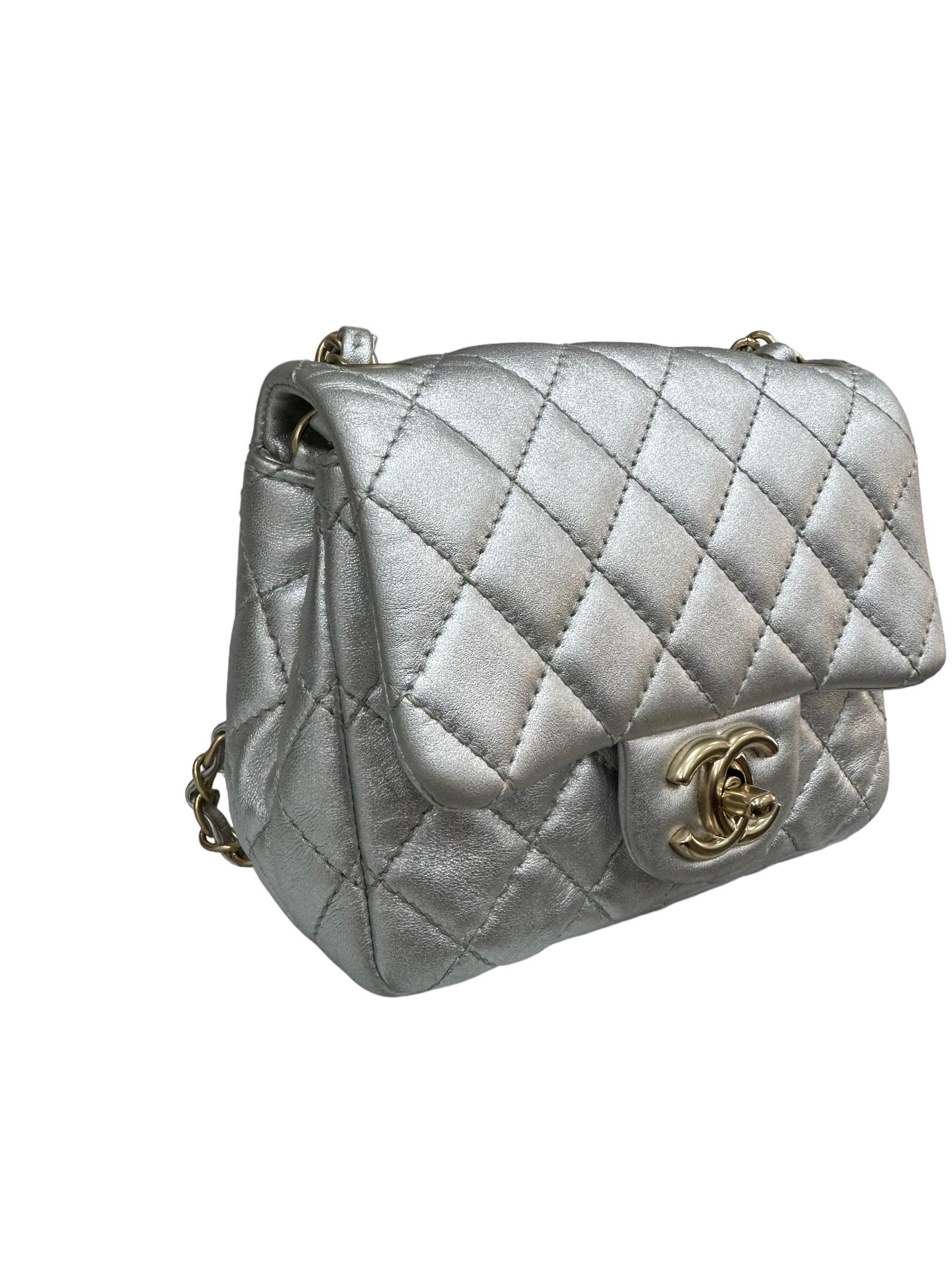 Chanel signed bag, Mini Flap model, made in silver leather with golden hardware. Equipped with a flap with CC logo twist lock, internally lined in silver leather, roomy for the essentials. Equipped with a braided leather and chain shoulder strap and