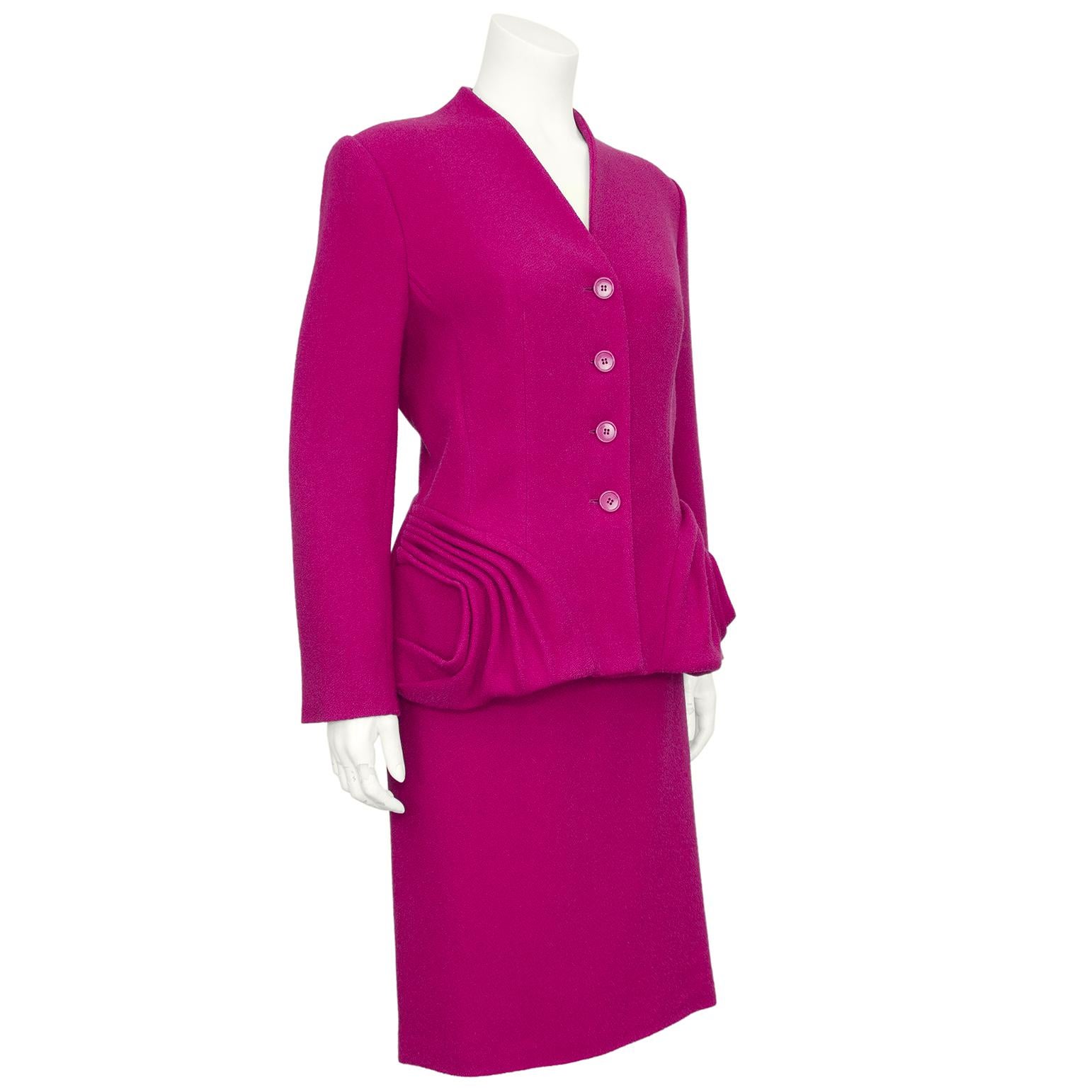 John Galliano for Christian Dior fucshia pink wool skirt suit from the 2009 collection. The suit mimics the 'New Look' shape created by Dior in 1947 with hips accentuated with rosette style pleated details. Buttons down the front, no lapel. The