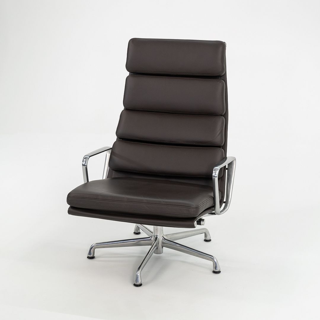 This is an Eames Aluminum Group Soft Pad Lounge Chair and Ottoman, model EA438, originally designed by Charles and Ray Eames in 1969. This example dates to 2009. The design features a cast aluminum frame with a 5-star base, and has thick padded