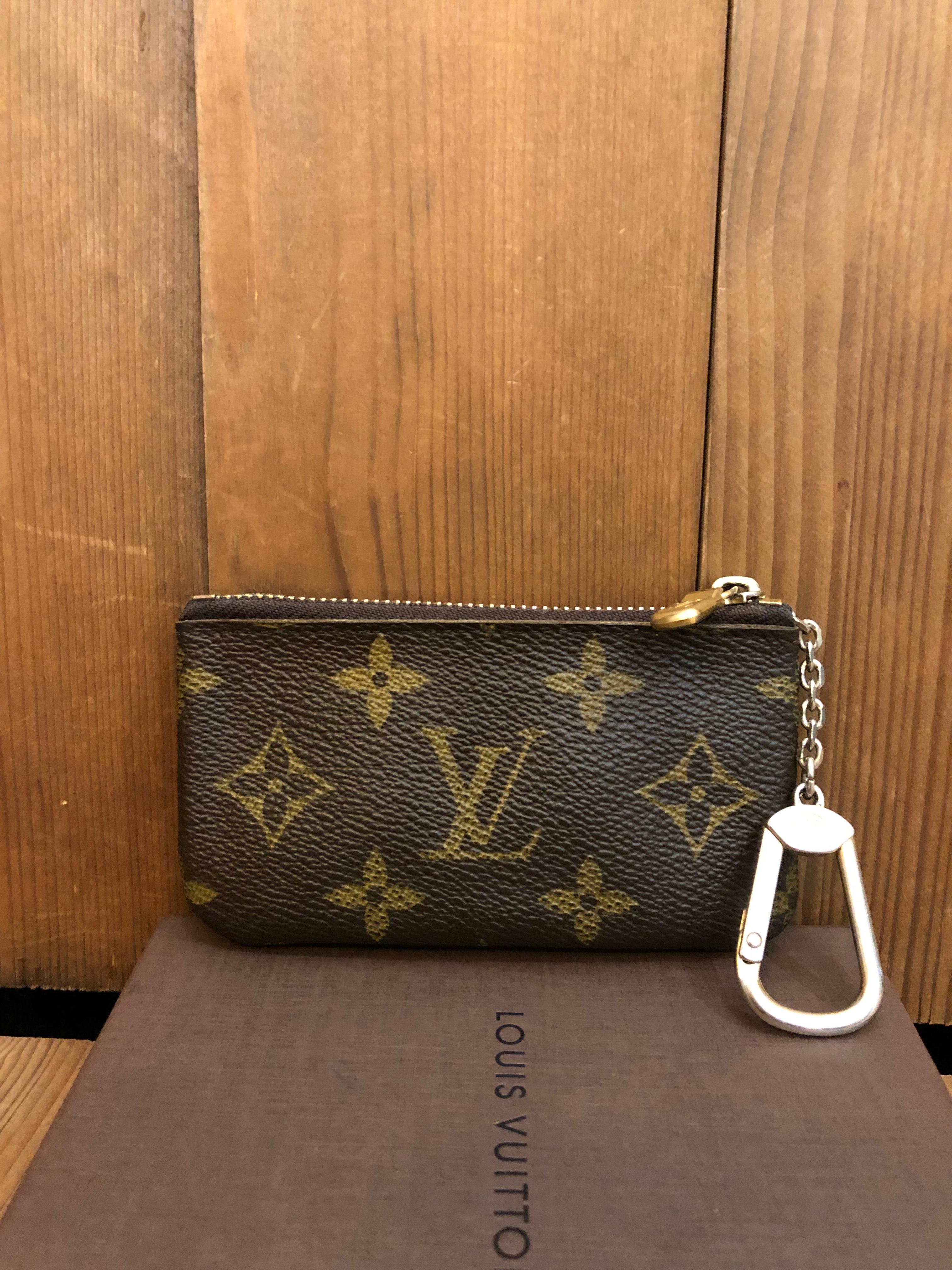 This LOUIS VUITTON key coin pouch is crafted of Louis Vuitton coated monogram canvas lined with terracotta cross-grain leather. A chic and very practical accessory from LOUIS VUITTON. Zipper top closure. This pouch features a D-ring clasp to secure