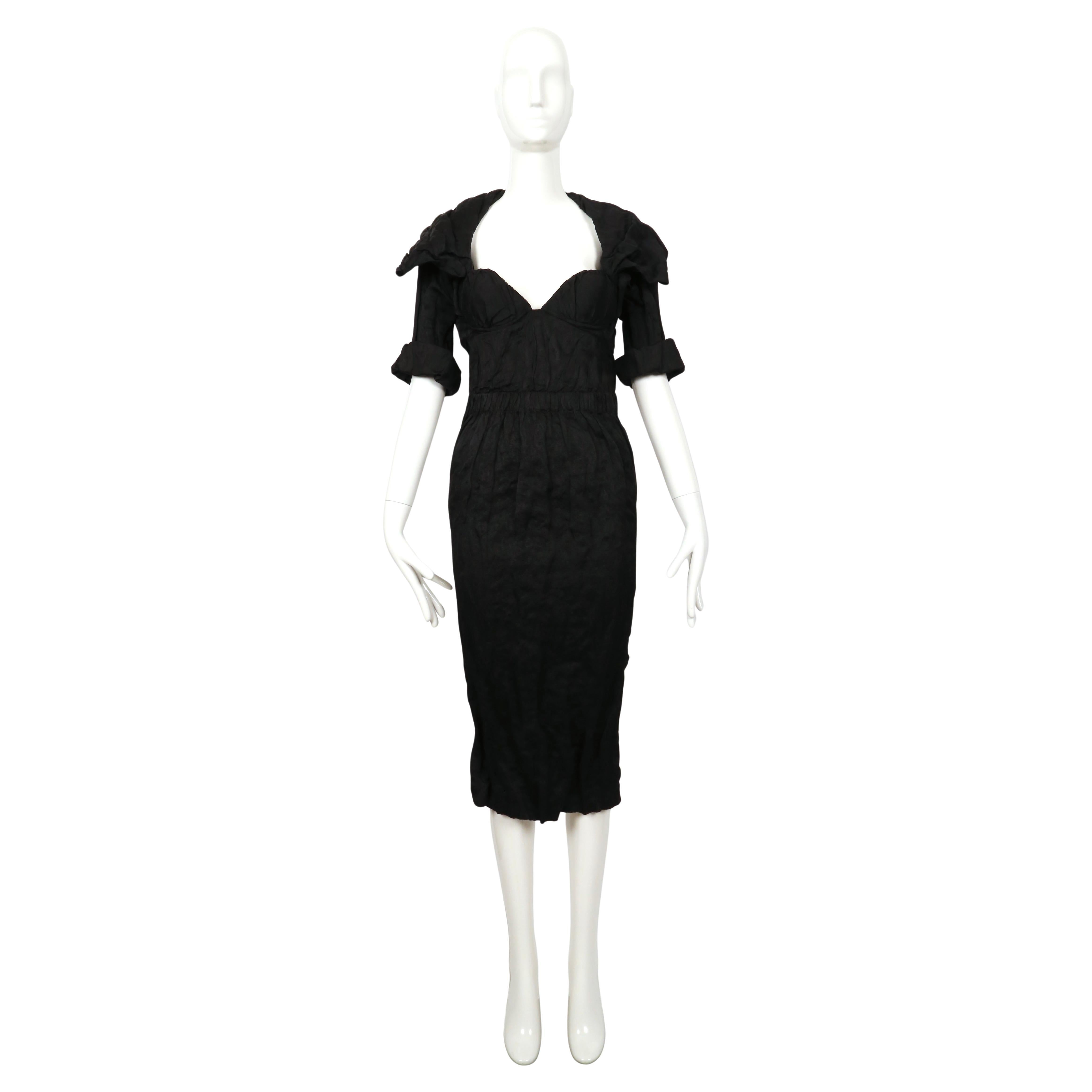 Jet black corrugated fabric dress with bustier and attached bolero jacket designed by Muccia Prada exactly as seen on the Prada spring 2009 runway. Labeled a size 40 however this fits slim through the hips. Approximate measurements: bust 32