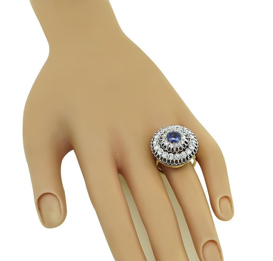 Questo è un affascinante anello in oro giallo e bianco 14k. L'anello è centrato da un delizioso zaffiro a taglio rotondo del peso di circa 1,00ct. Lo zaffiro è accentuato da scintillanti diamanti a taglio rotondo che pesano circa 2.00 carati. Il