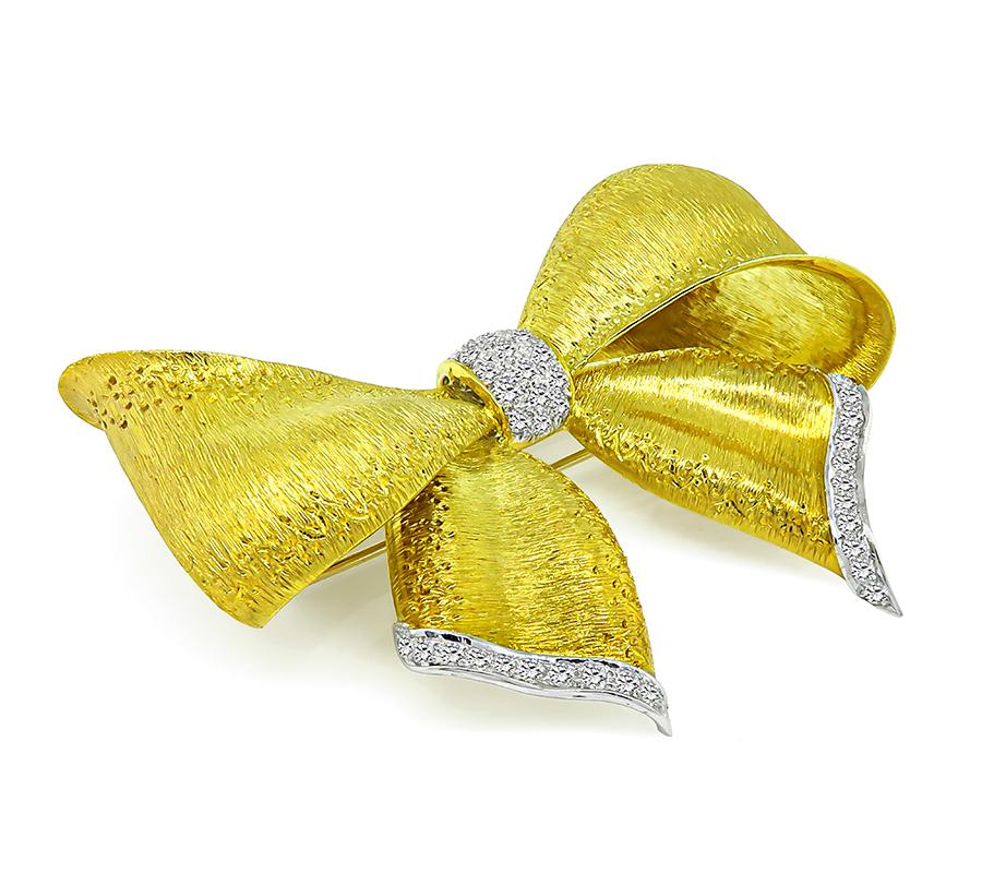 This is a gorgeous 18k yellow and white gold bow pin. The pin is set with sparkling round cut diamonds that weigh approximately 2.00ct. The color of the diamonds is G with VS clarity. The pin measures 50mm by 68mm and weighs 31.6 grams. The pin is