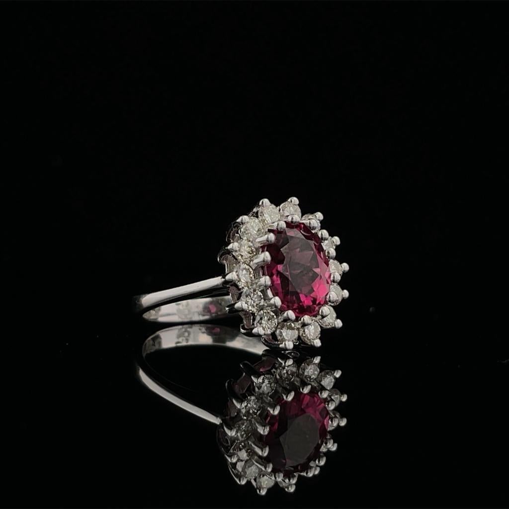 Gorgeous, gorgeous, gorgeous!!! 
The ring is made in 14K White Gold with a 2.00CT Pink Tourmaline Center. It is surrounded with Fourteen (14) Round Diamonds Weighing 0.42CTW in a Halo Setting. It is currently at a size 6.  