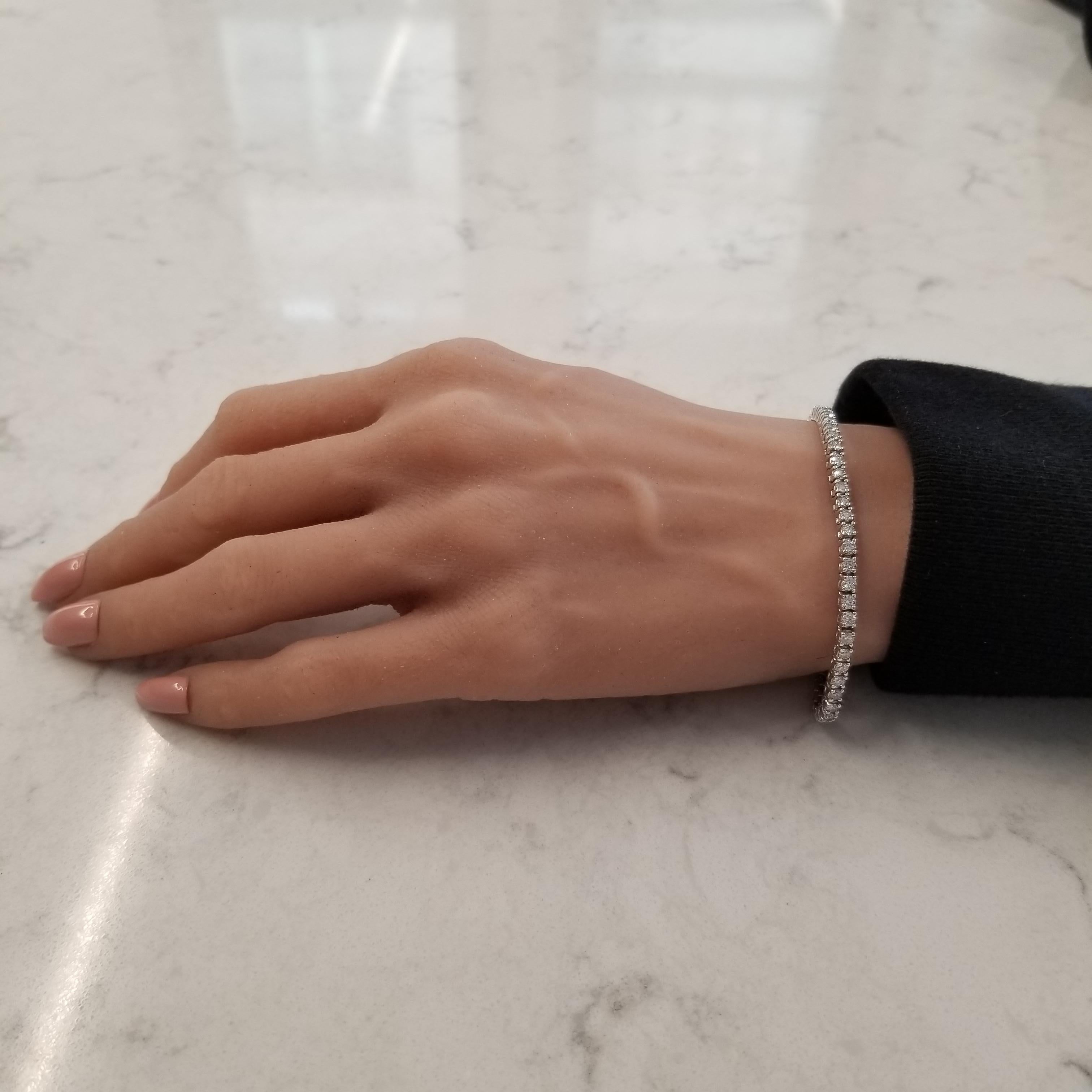 This spectacular brightly polished 14 karat white gold tennis bracelet showcases a stunning 2.01 carats of round brilliant cut diamonds. A total of 78 diamonds that measure 2.00mm in diameter each are prong set into beautiful basket links on this