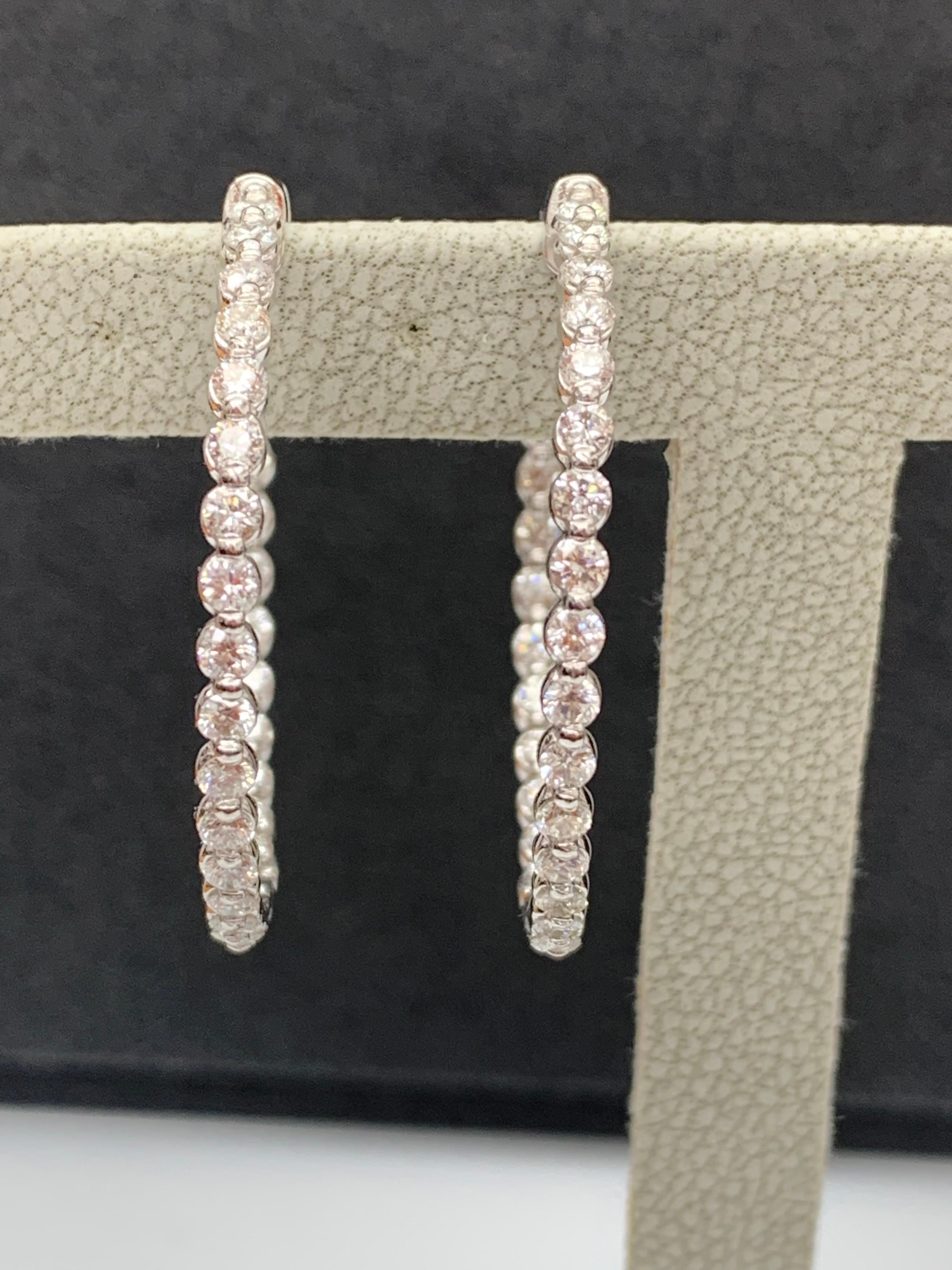 Gorgeous and classic diamond hoop earrings. Features dazzling brilliant cut round diamonds set in shared prongs to maximize the brilliance of the diamonds. The total weight of the 60 diamonds is 2.01 carats. Made in 14k white gold. 