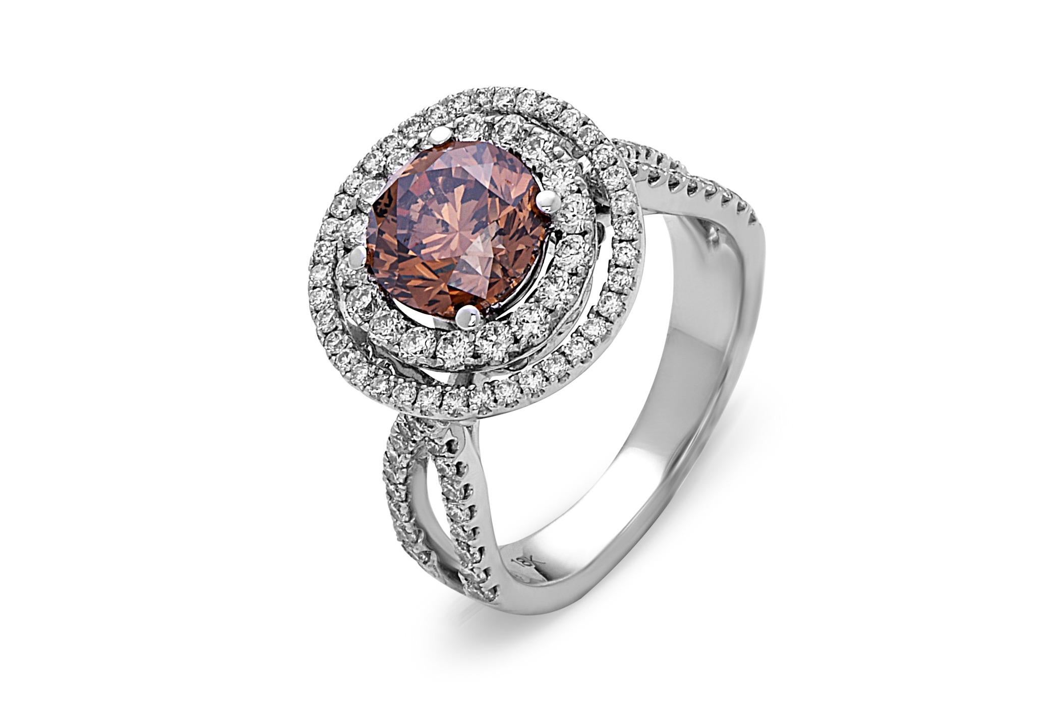 This cocktail ring showcases a stunning 2.01 carat round brown diamond set in 18 karat white gold encircled by a double diamond halo, on a double diamond shank. T

Total diamond weight (not including center stone) = 1.08 carats. Ring size is 6 1/2.