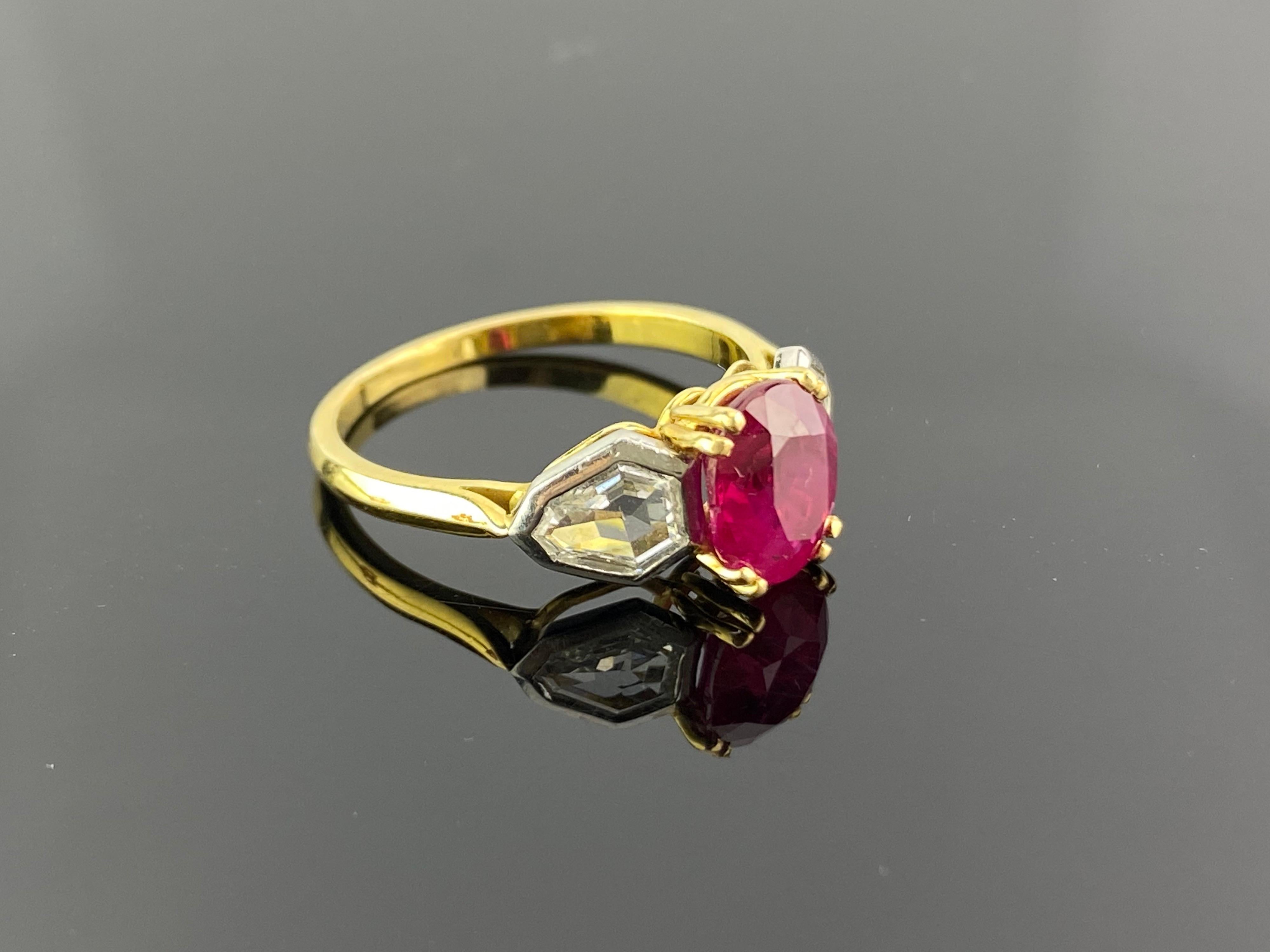 A beautiful 2.01 carat, pigeon blood oval Burmese Ruby and fancy cut Diamond three-stone engagement ring.  The Diamonds are colorless and VVS quality, and the stones are set in solid 18K Yellow and White Gold. The ring is currently sized at US 6,