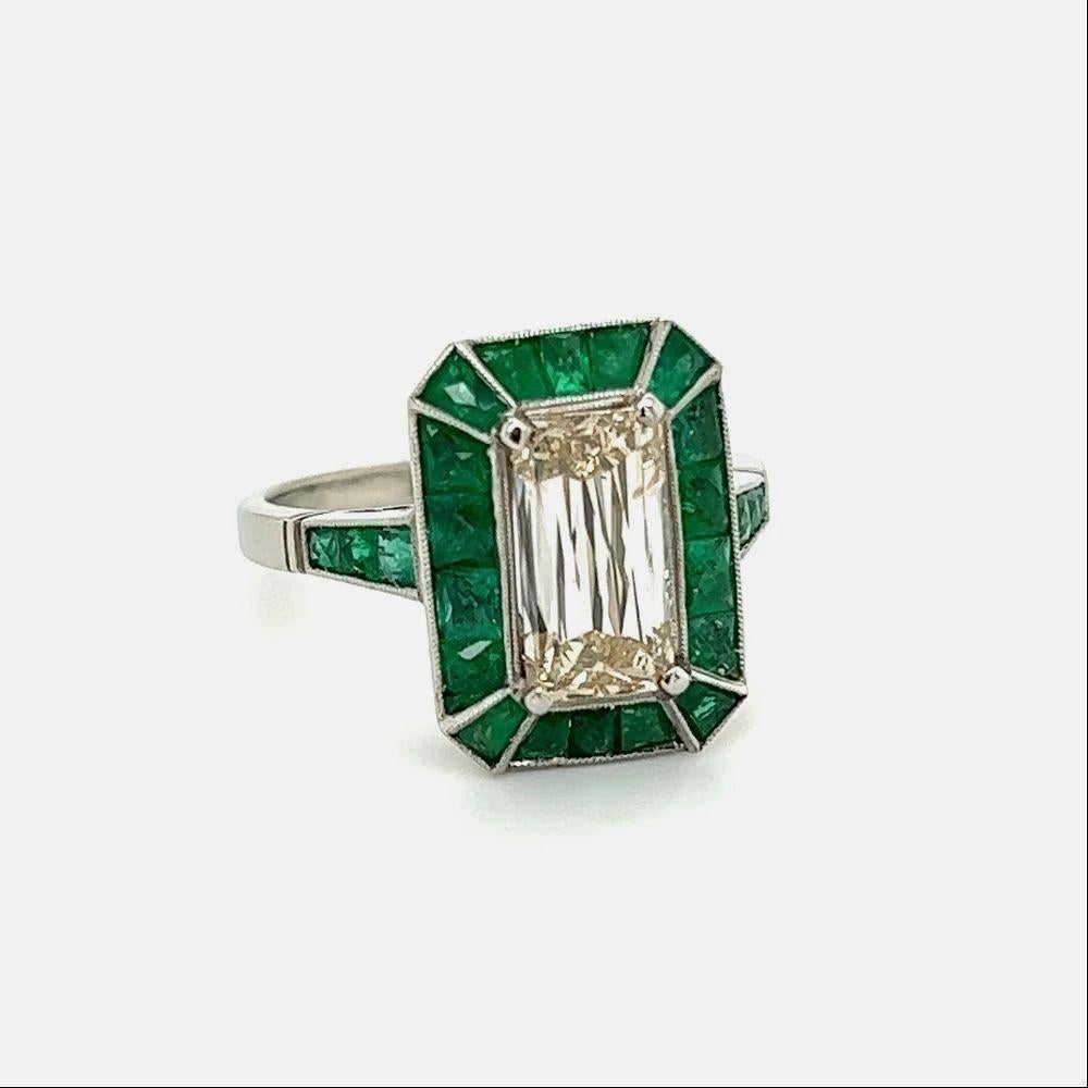 Simply Beautiful! Finely detailed Rectangular Crisscut Diamond and Emerald Platinum Ring. Centering a securely nestled Hand set Rectangular Crisscut Diamond, weighing approx. 2.01 Carats. Light Yellowish Brown natural Diamond SI2. Surrounded by
