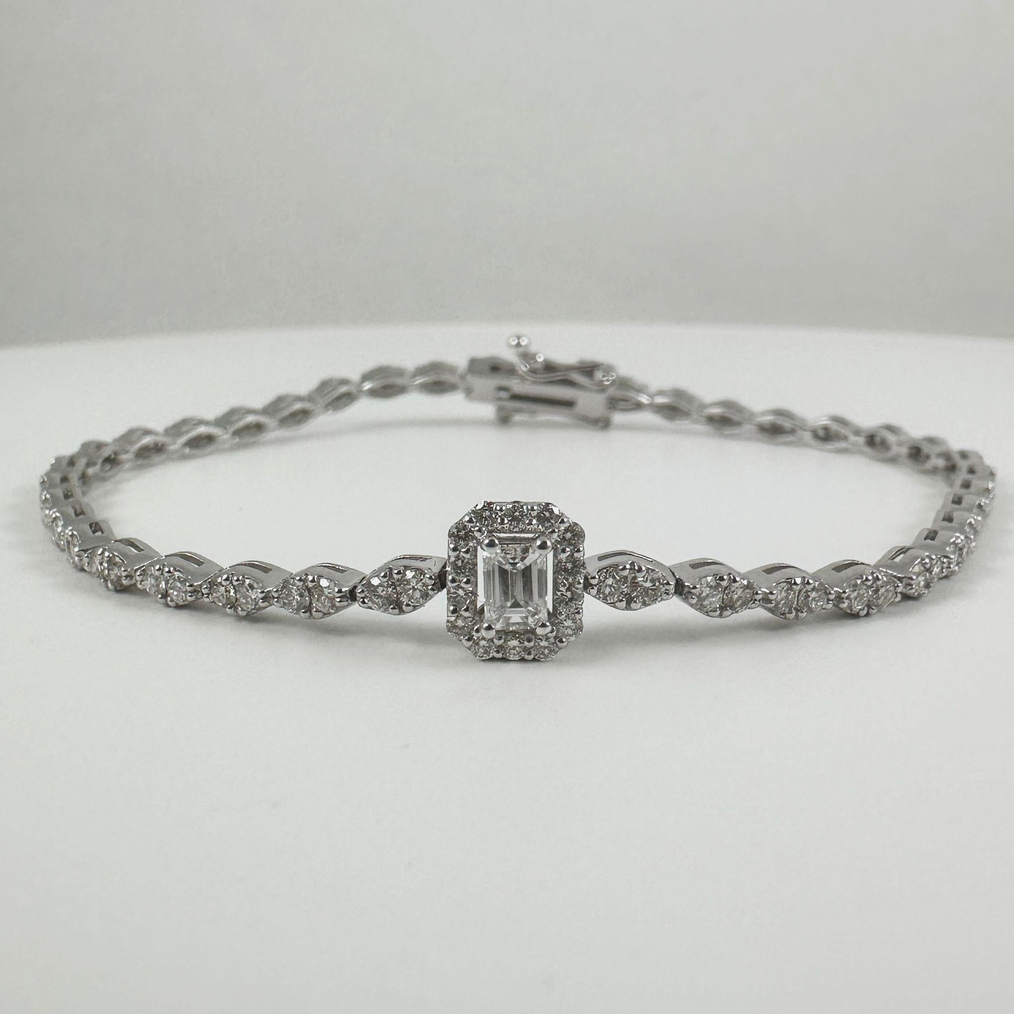 This elegant bracelet features a stunning emerald-cut diamond center, graded VS clarity, for exceptional brilliance and refinement. Surrounding the centerpiece is a delicate halo of round brilliant-cut diamonds in G-H color and SI clarity, enhancing