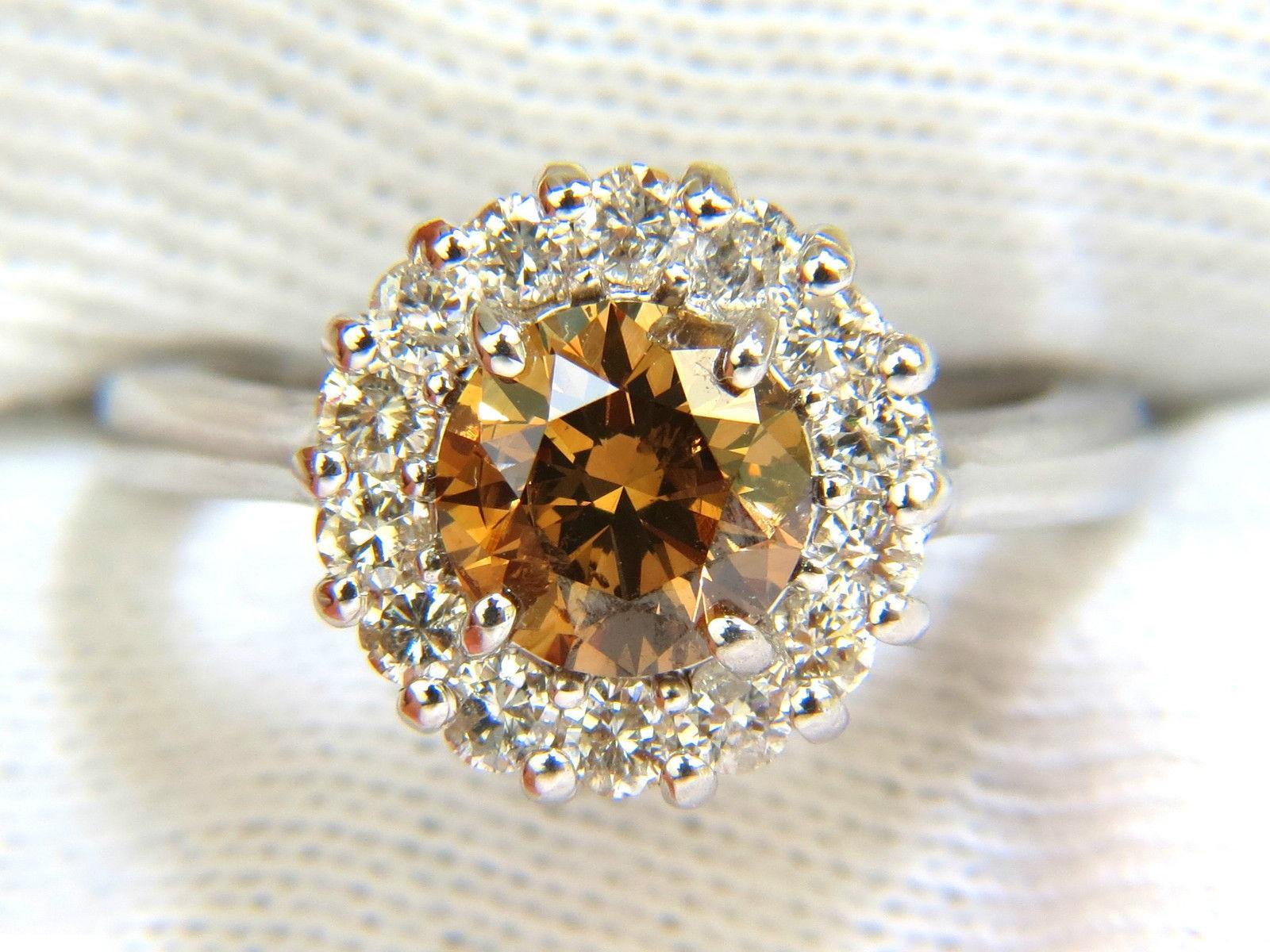 1.35ct. Natural Fancy color Orange Brown diamond

Round, brilliant full cut 

Si-1 clarity

Diamond is 6.9mm wide
Beautiful  sparkles throughout



.66ct. Side diamonds:

Full cuts and rounds 

G-color Vs-2 clarity.

Video of ring upon