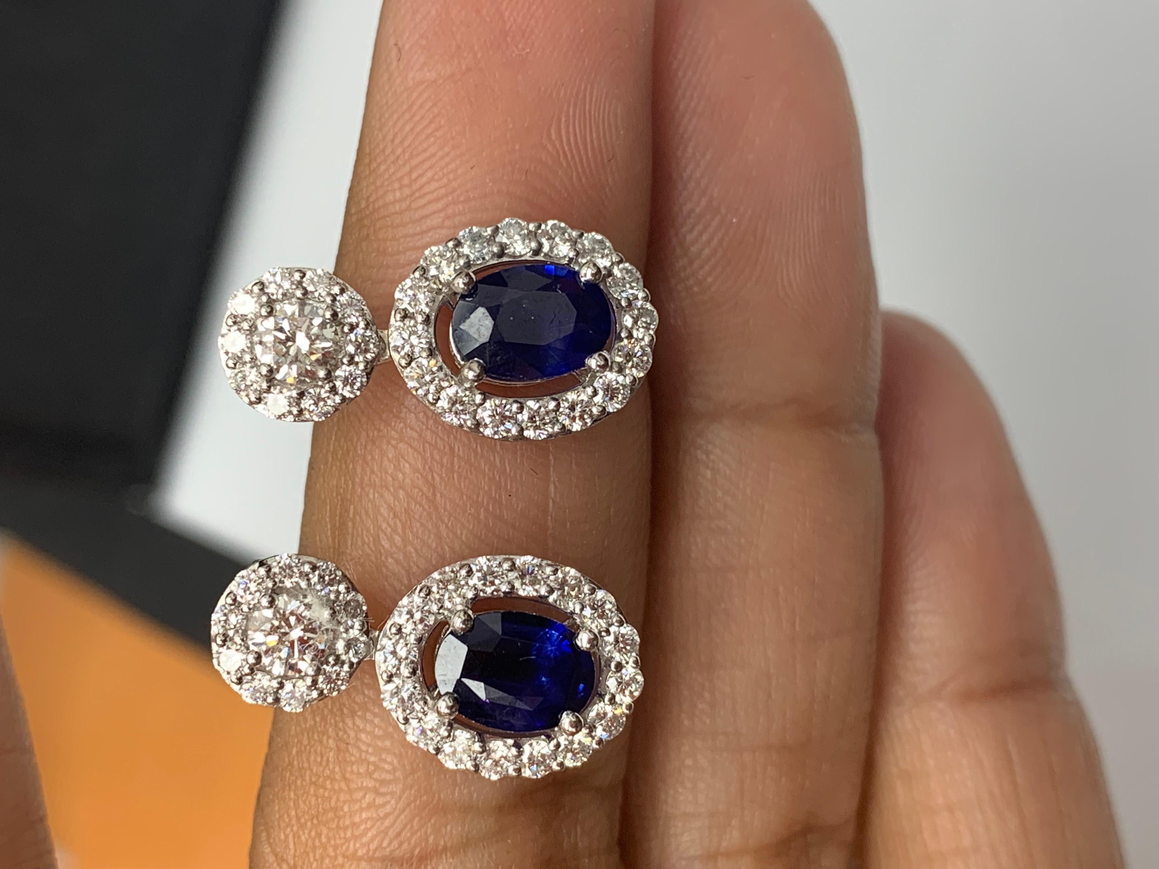 Une belle et chic paire de boucles d'oreilles pendantes mettant en valeur des diamants de taille brillant et des saphirs bleus de forme ovale, le tout serti dans un design complexe et élégant. 2 Diamants sur le dessus pèsent 0,37 carats au total.  2