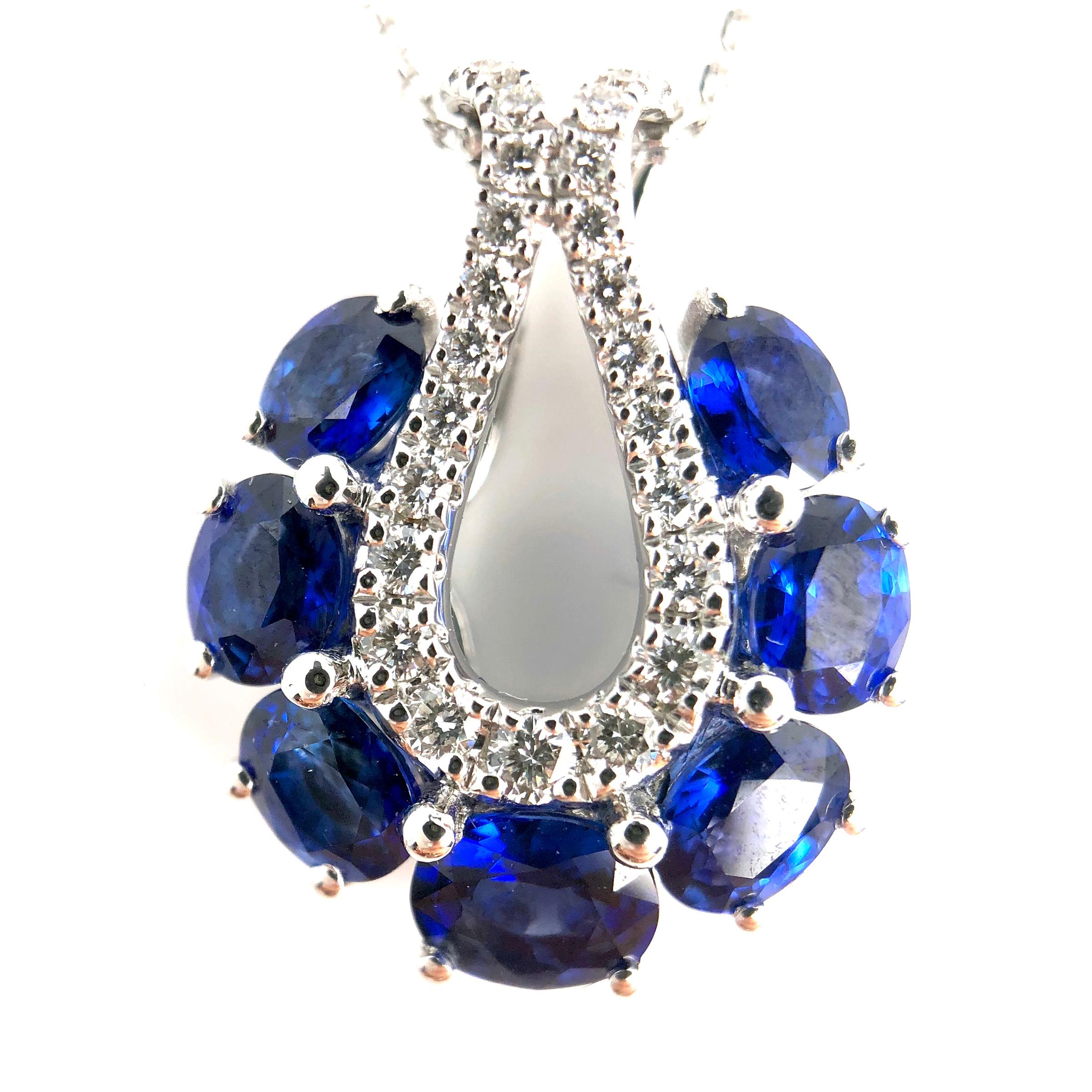 This lovely halo pendant features seven oval cut blue Sapphires, total 2.01 carats, encircling an open teardrop setting of round white diamonds.

Center: 2.01 carats blue sapphire
Diamond Halo: 25 round diamonds total 0.26 carats
Set in 18k White