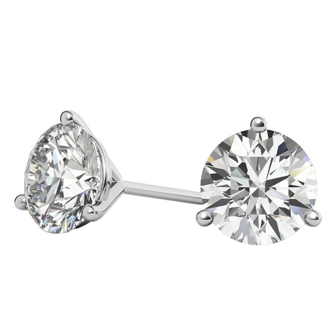 This classic pair of Natural diamond stud earrings features two gorgeous round brilliant cut diamonds. These diamonds weigh 1.01 and 1.00 with (H color), (SI2/SI3) clarity. They are elegantly set in Martini-style 3-prong settings. These diamonds are