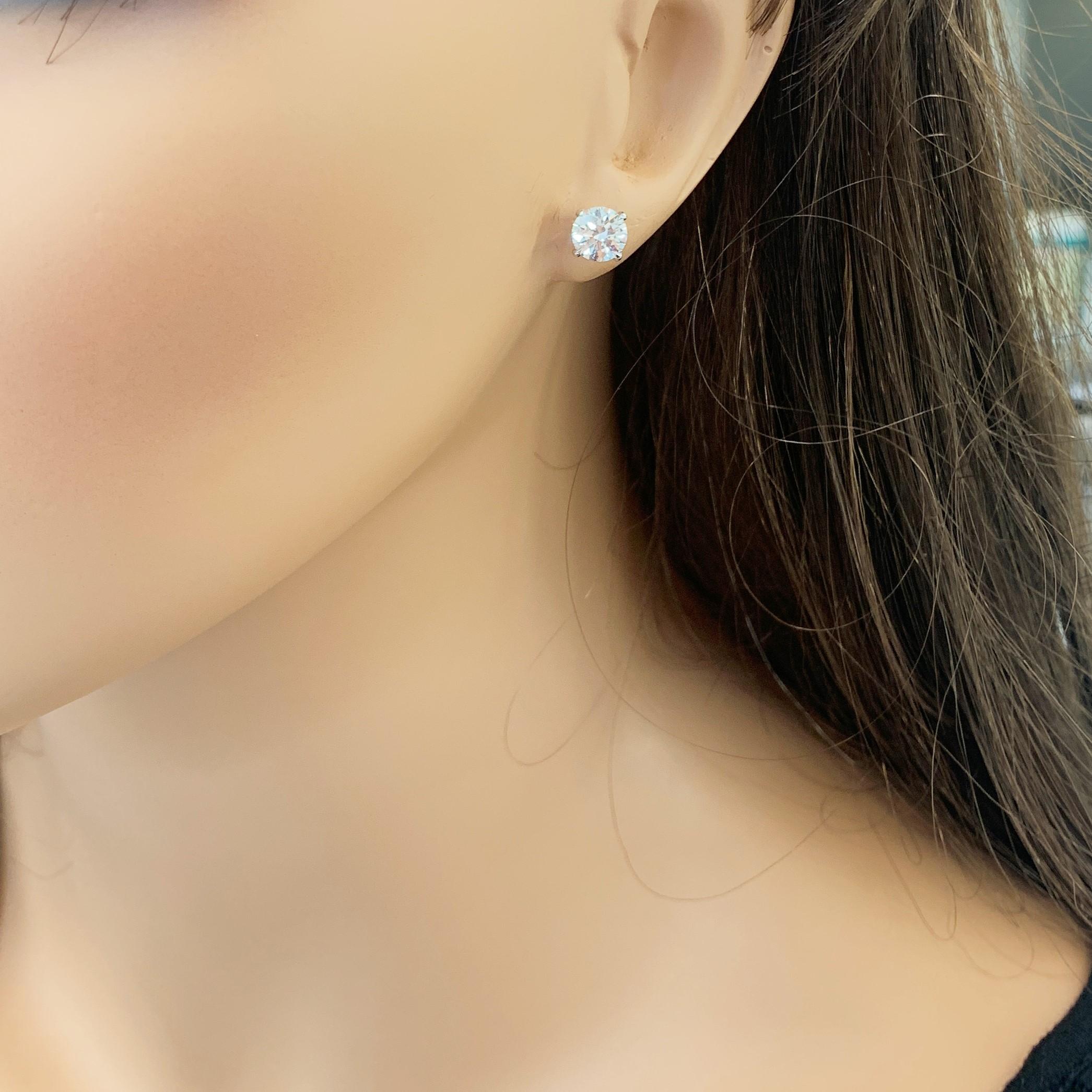 Stunning 14 Karat white gold handmade earrings featuring 2 round brilliant cut diamonds weighing 2.01 carat total J color VS2 clarity. The stunning earrings measure 6.25 - 6.31 mm in diameter, these gorgeous earrings are classic and timelessly