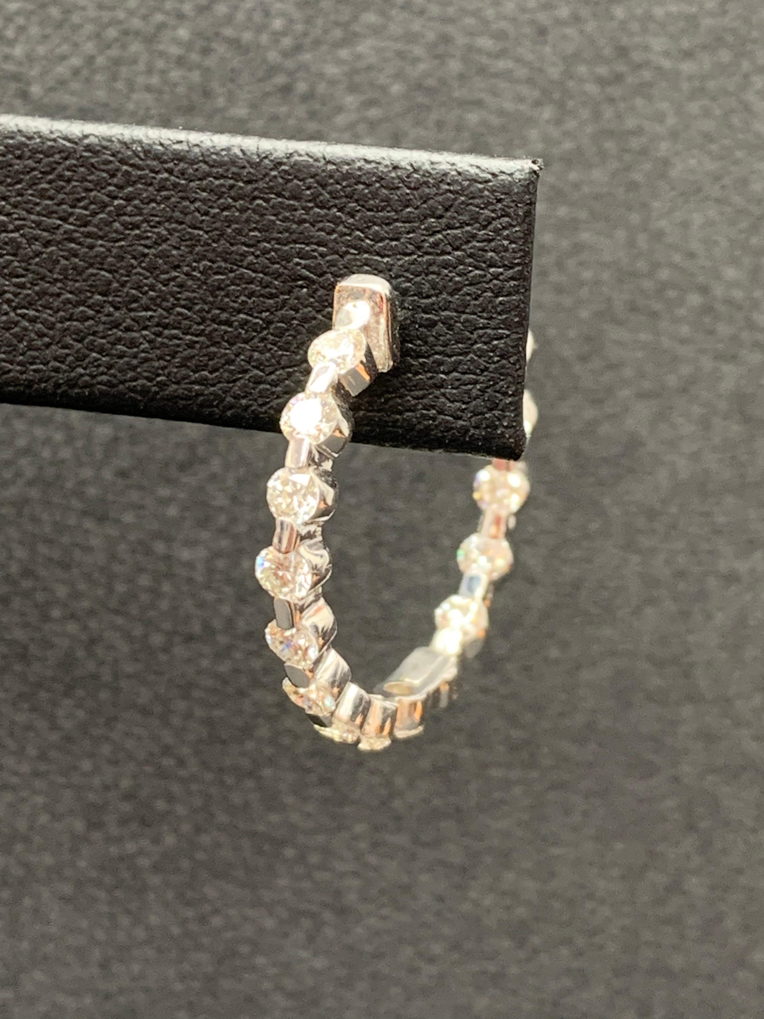 Gorgeous and classic diamond hoop earrings. Features dazzling round diamonds set in shared prongs to maximize the brilliance of the diamonds. The total weight of the 28 diamonds is 2.01 carats. Made in 14k white gold. Approximately 1.65 inches in
