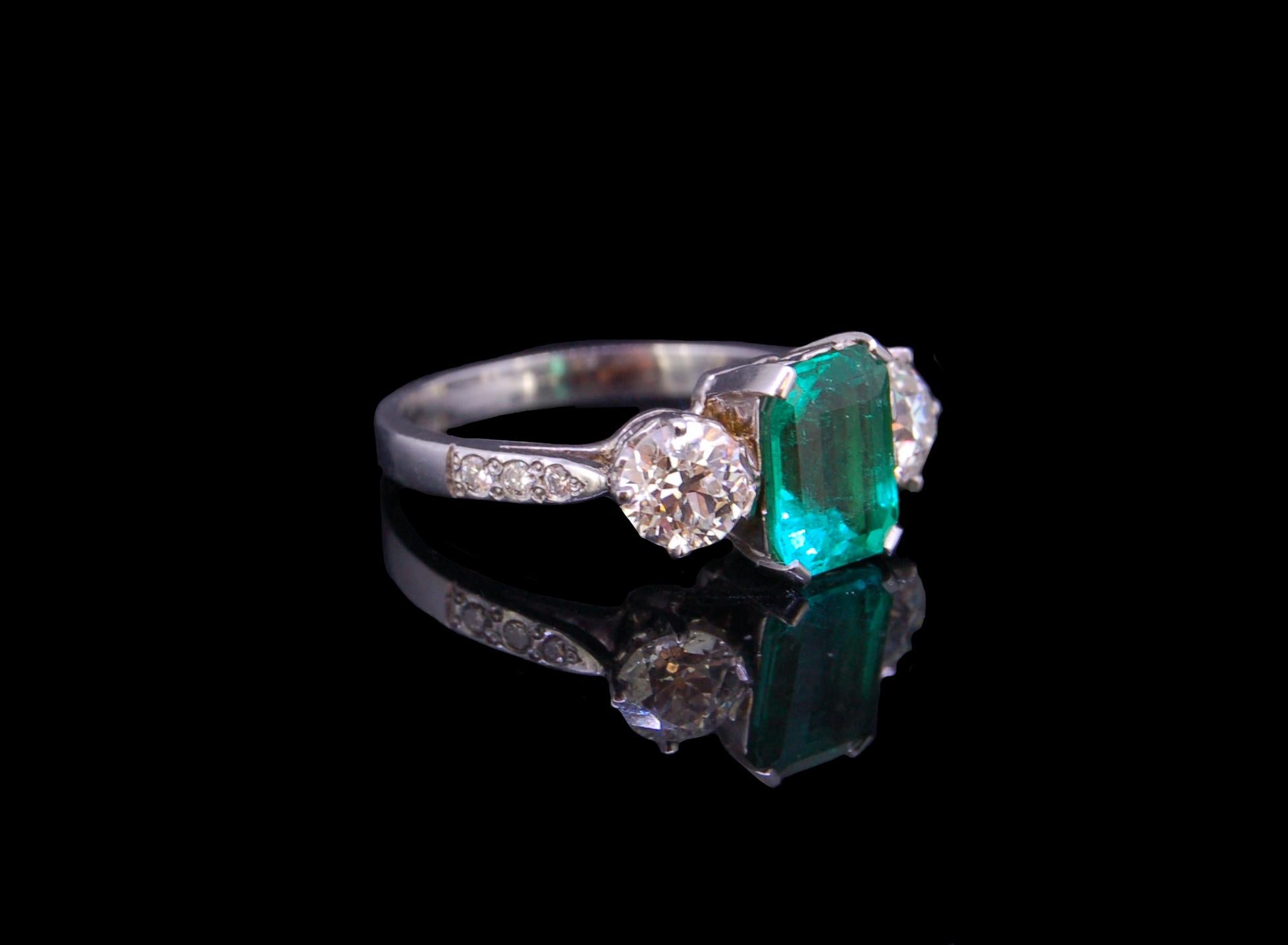 2.01 ct. COLOMBIAN EMERALD AND DIAMOND 3-STONE RING, set with a central octagonal emerald of 2.01 ct. flanked by diamonds on the shoulders totalling 1.14 ct. Size O. 3.9 grams. Accompanied by GCS London report No. 80249-20 stating that the 2.01 ct.