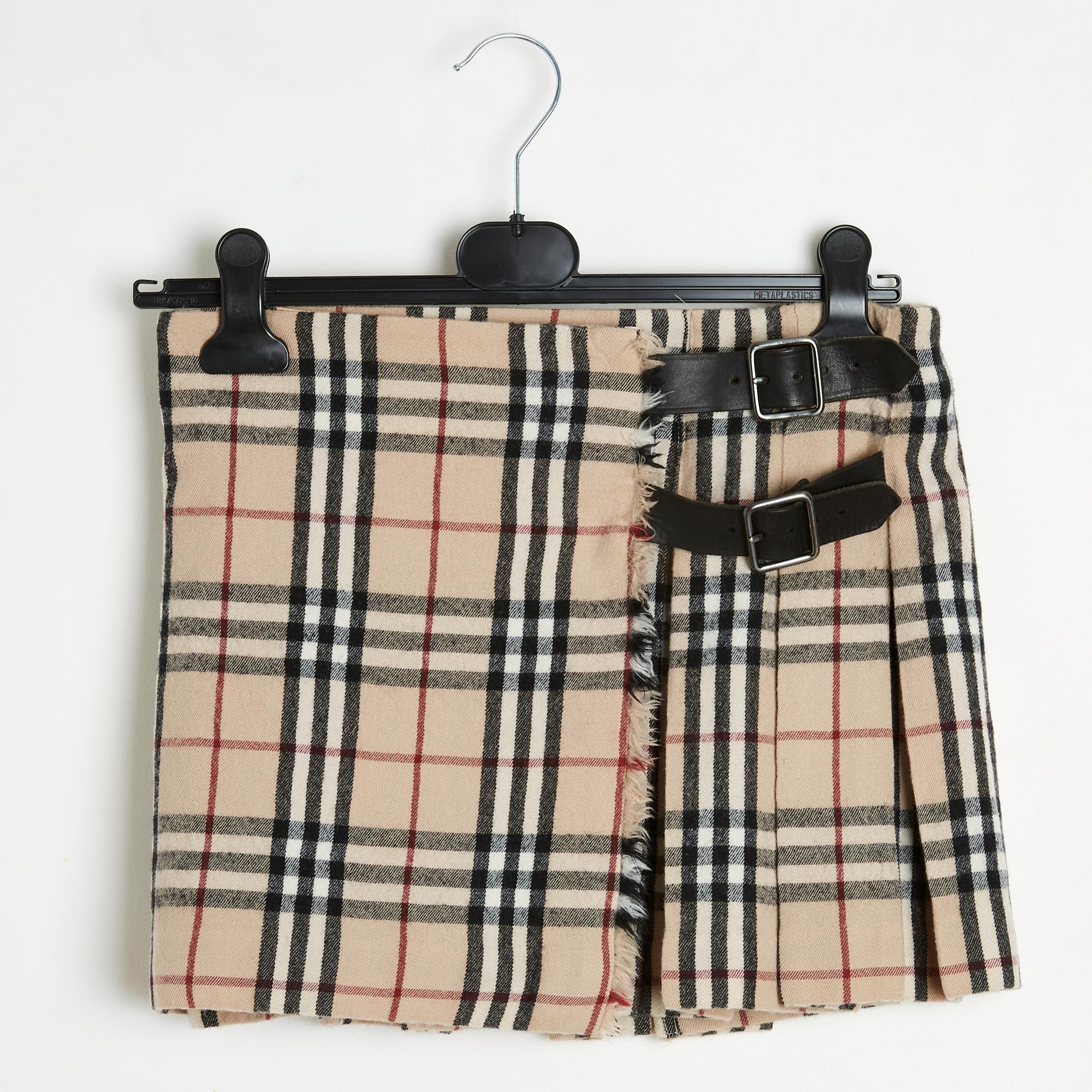 Burberry kilt-style skirt, mini pleated wool in Scottish pattern or Vintage Check in camel beige, ecru black tones, low waist, adjustable cross closure with two pin buckles on brown leather tab on each side, unlined. Size UK10 or 38FR: waist 38 cm,
