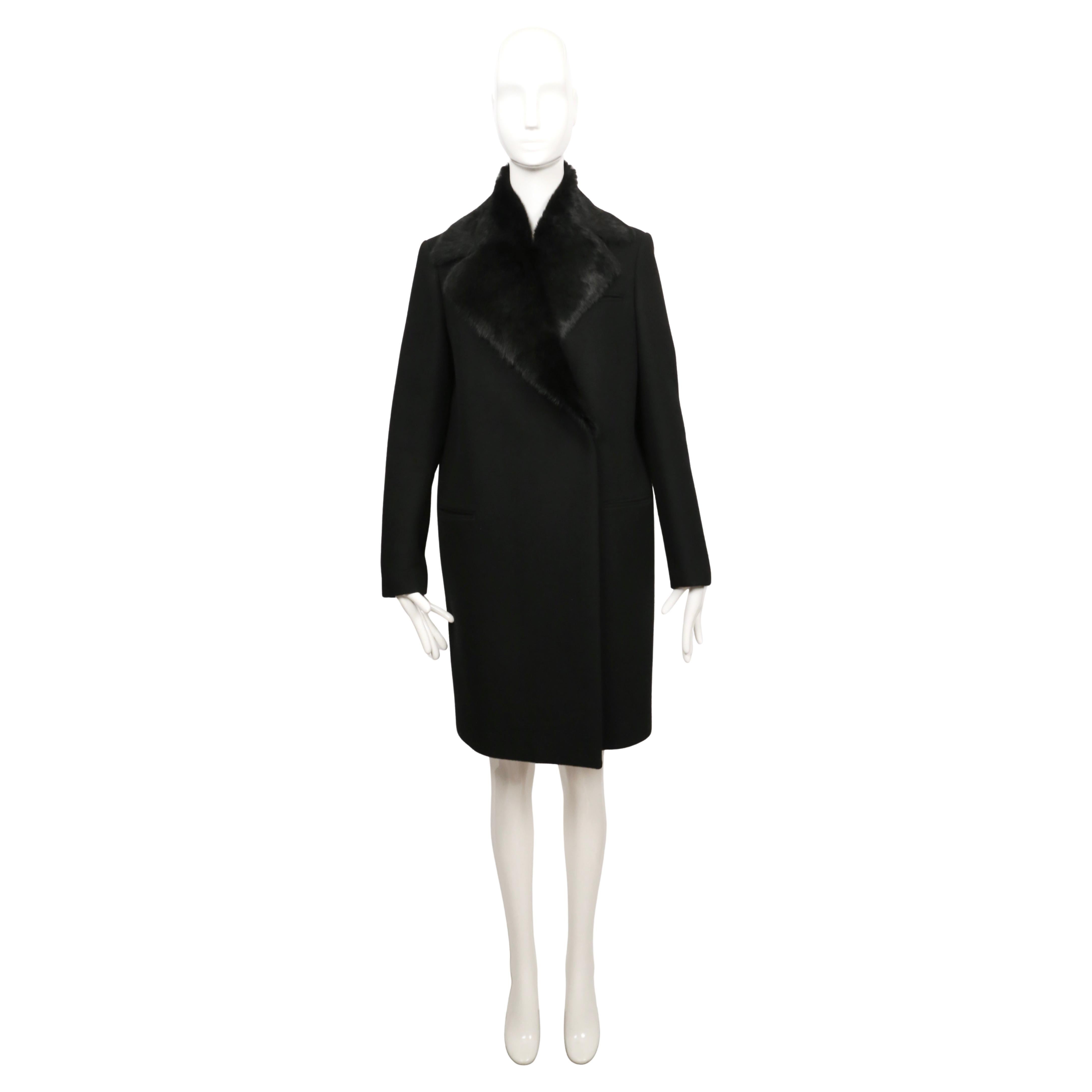 A 2010 wool crombie coat designed by Phoebe Philo for Céline. It’s cut in a sharp, minimal line with a single-breasted front and discreet welt pockets. The standout detail is the oversized rabbit fur collar, which can be removed for a simpler look.