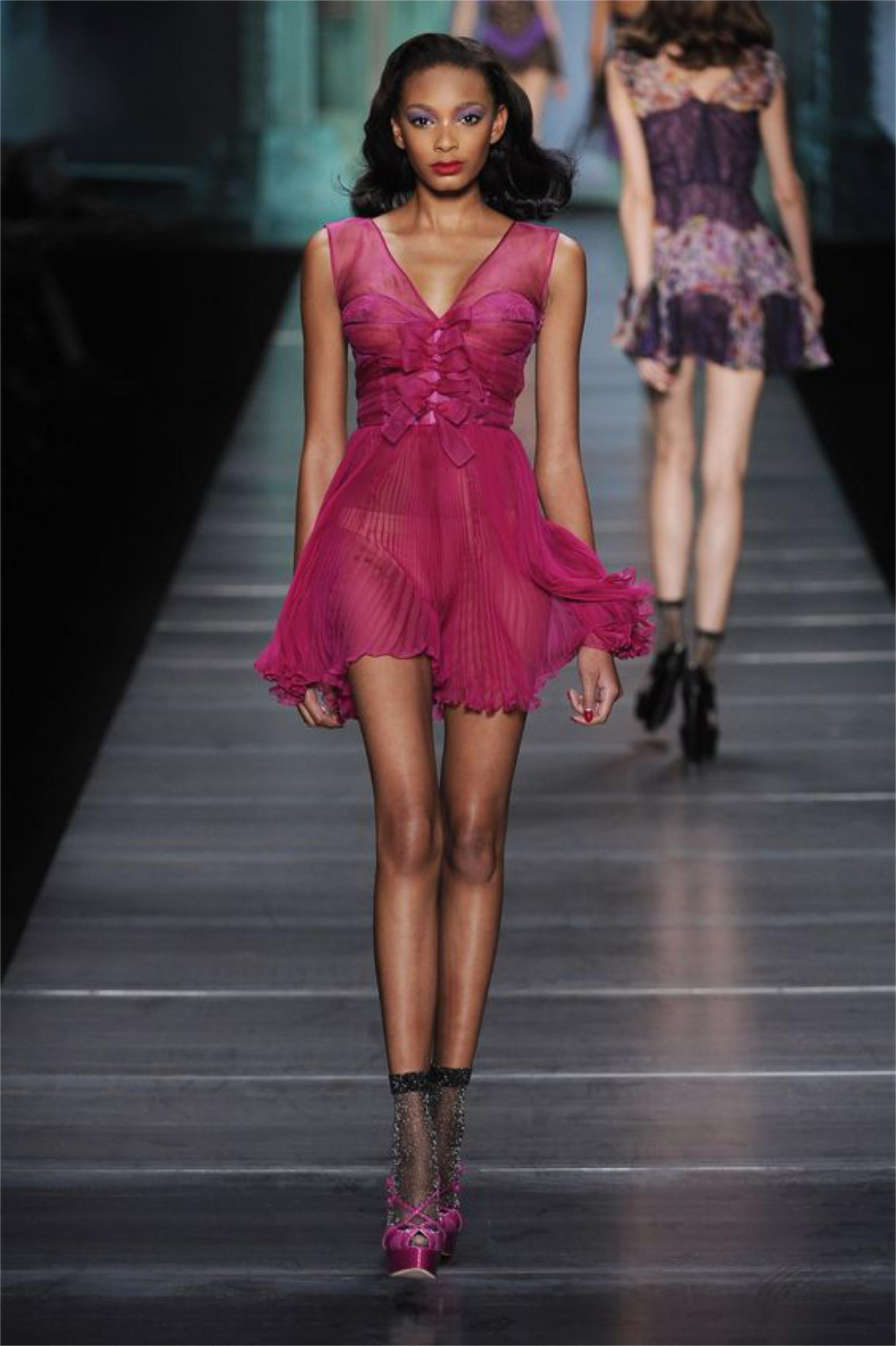 Un codiciadísimo e increíblemente asombroso mini vestido lencero plisado de seda transparente y encaje rosa fucsia de Christian Dior que data de la épica colección de pasarela primavera/verano 2010 de John Galliano. Vogue declaró: 