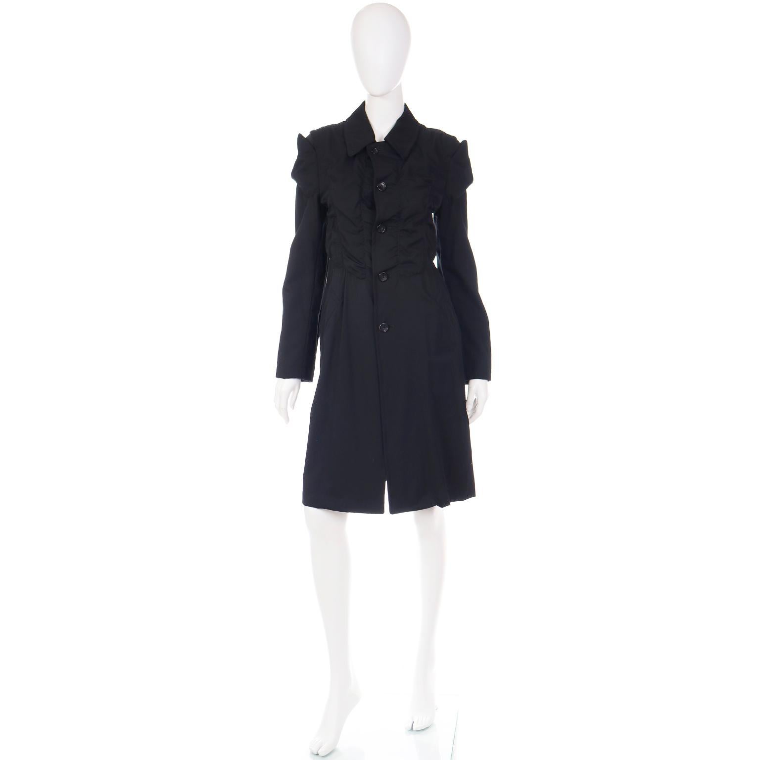 This is such a great Comme des Garcons coat with Rei Kawakubo's signature touches and beautiful ruching on the bodice. The coat has front side slash pockets and buttons up the center front. There is a center back 19