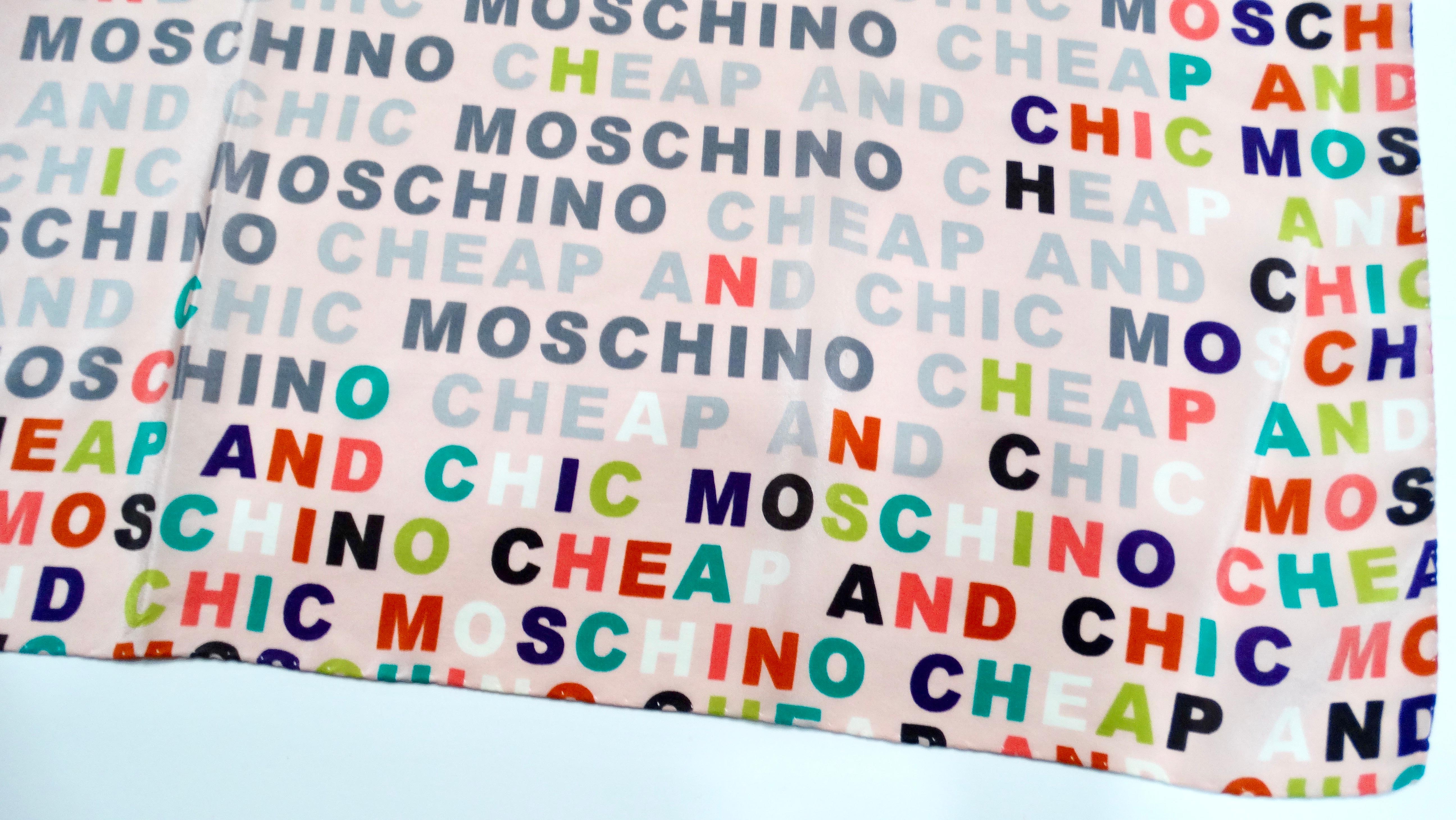 The 2010 Moschino Cheap & Chic Pink Multicolor Logo Print Silk Scarf is a vibrant and playful accessory that embodies the brand’s signature whimsical charm. Adorned with the iconic 