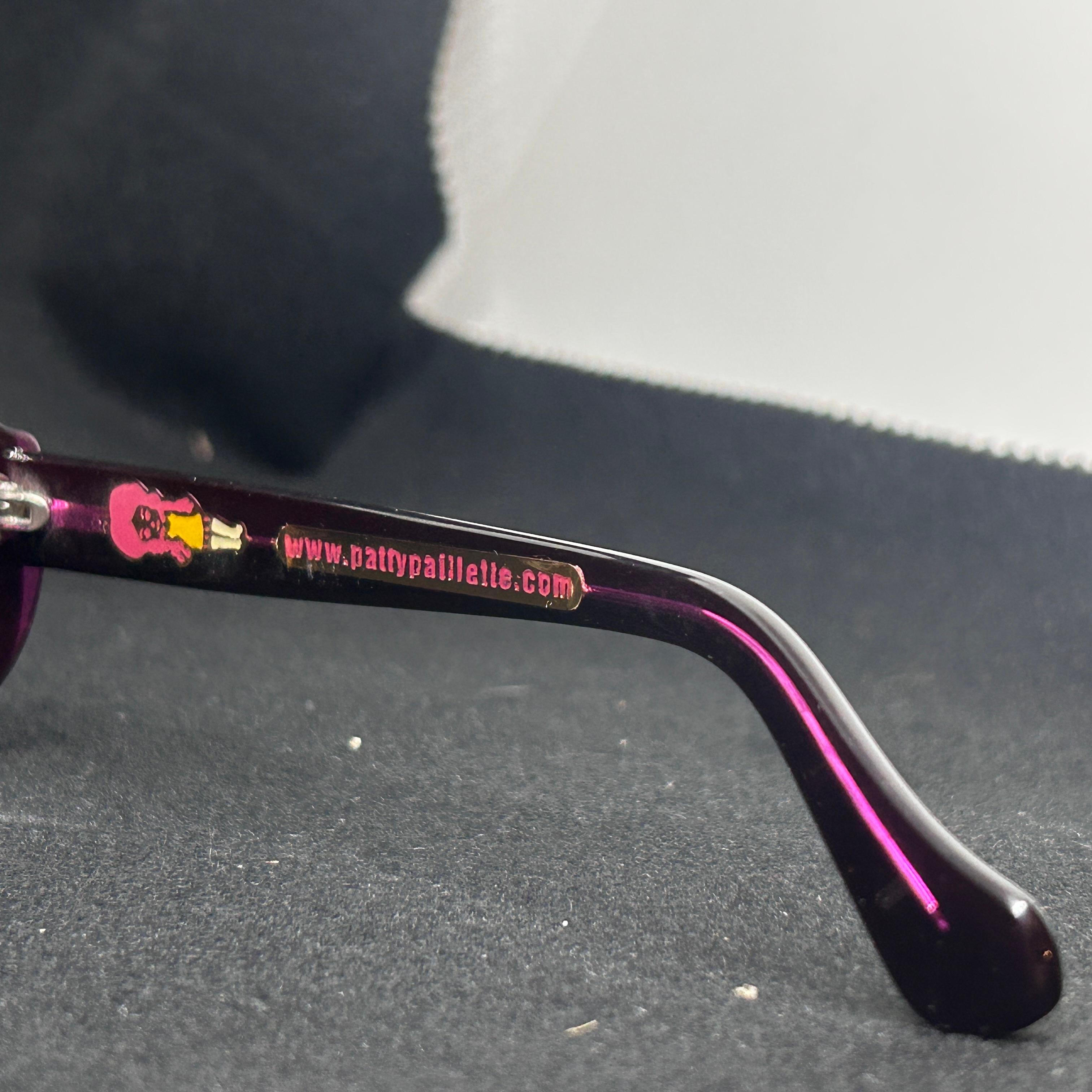 These are a pair of Retro Purple and White Italian Oversize Sunglasses by Patty Paillette, a designer known for her distinctive and bold eyewear established in Venice, Italy.
This combination of colors and style reflects a playful yet luxurious