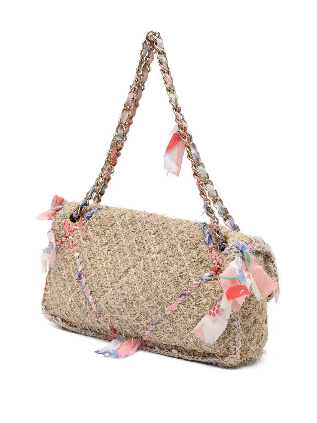 Du défilé printemps/été 2010 de Chanel
Beige
Paille
Matériel de couleur or
Garnitures et détails en ruban multicolore
Fermeture à rabat sur le devant
Chaîne et ruban entrelacés
Compartiment principal
Doublure illustrée de fleurs
Poche intérieure