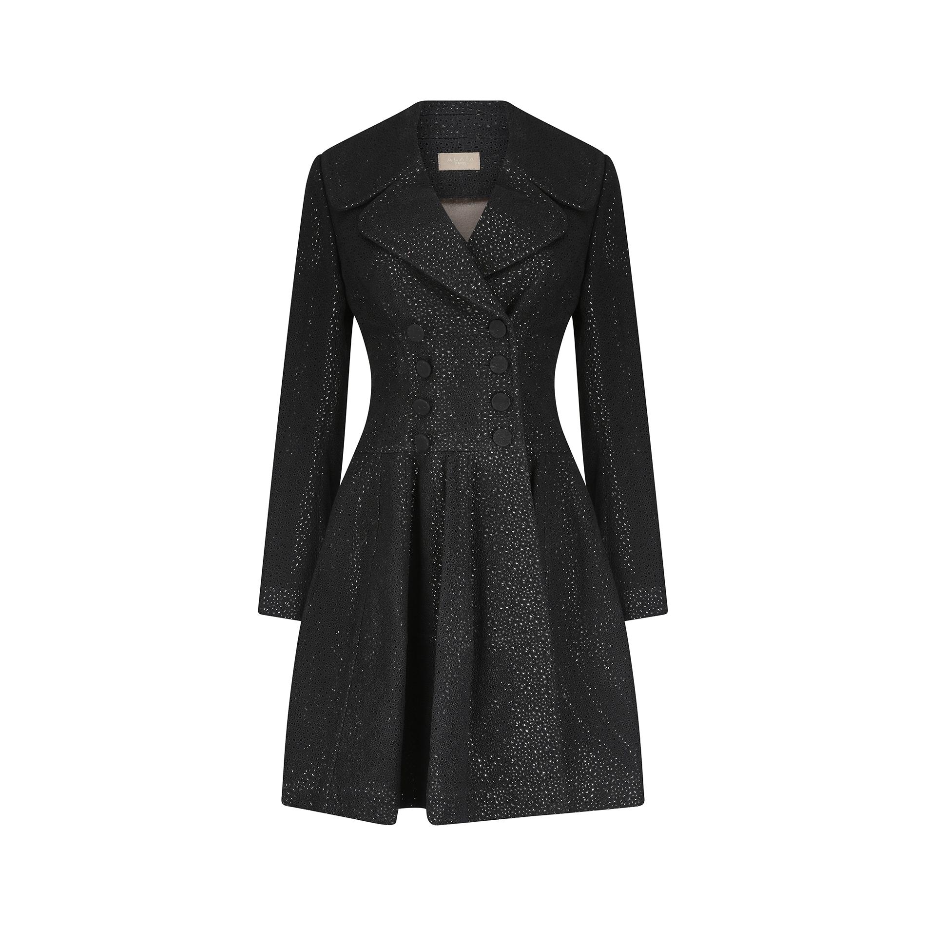 This fabulous early 2010s Alaia coat is cut in a classic princess shape, which creates a flattering, feminine silhouette. The fabric is comprised of a thick black garbardine cotton blend with a fine floral embroidered eyelet cut out design allover. 