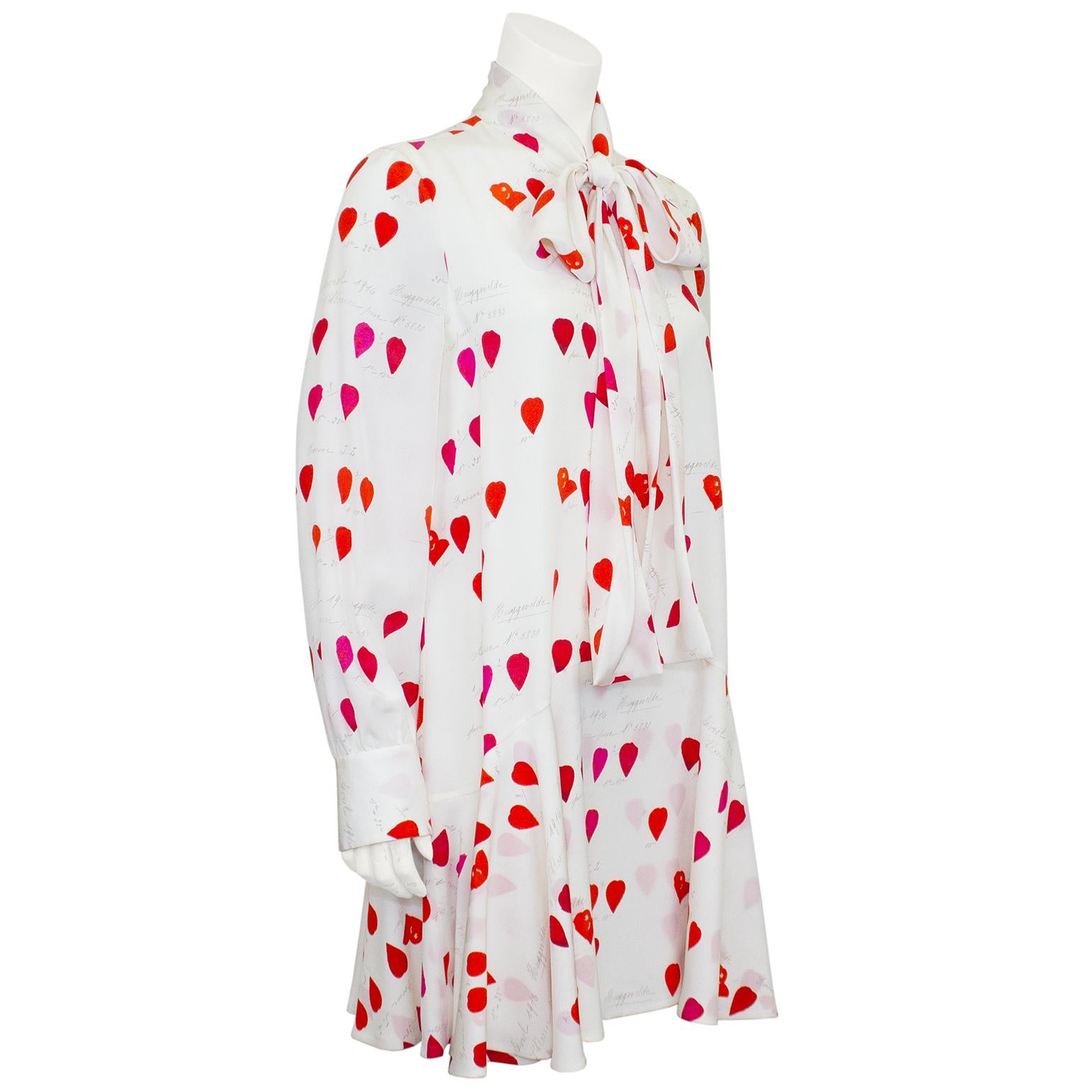 Flirty Alexander McQueen silk mini day dress/tunic from the mid 2010s. The dress has an all over red heart print on a white background with handwritten notes throughout. Lovely details of a necktie to be worn tied or loose at the neckline. Flounce