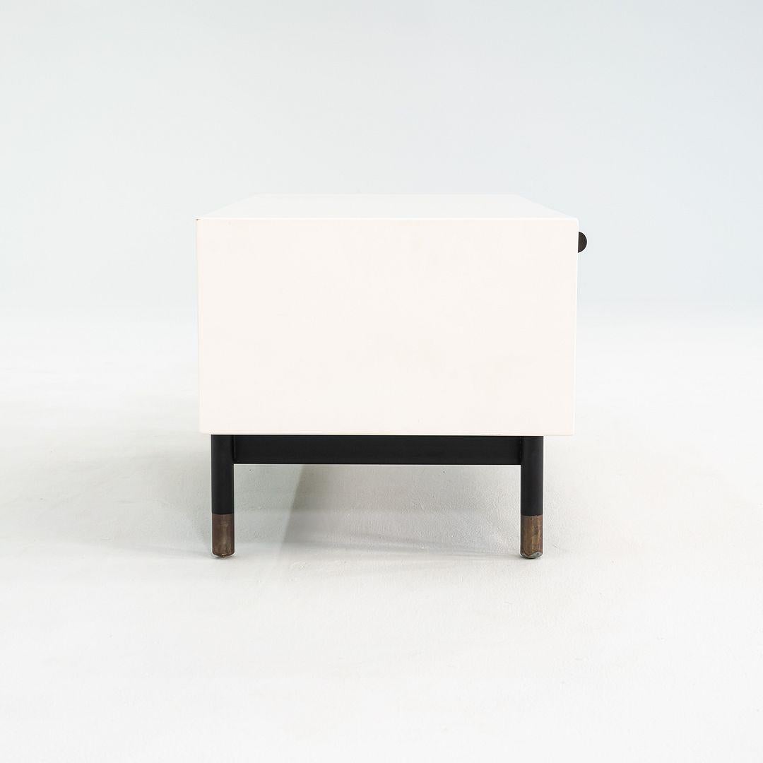 Si tratta di un comodino a basso profilo, originariamente progettato da Tyler Hays per BDDW. Questo particolare esemplare è stato prodotto negli anni 2010 in Pennsylvania. Il design prevede una cassa con un grande cassetto in legno laccato su gambe