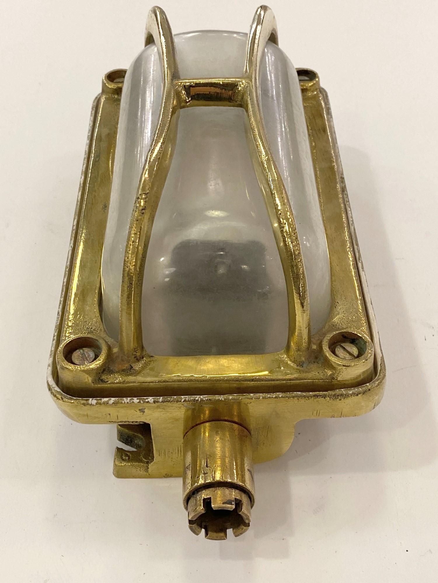 2010s solid brass rectangular nautical bulkhead ship light sconces with a clear glass lens. Industrial style. Has one E26 standard household light bulb socket. Cleaned and rewired. Small quantity available at time of posting. Priced each. Please