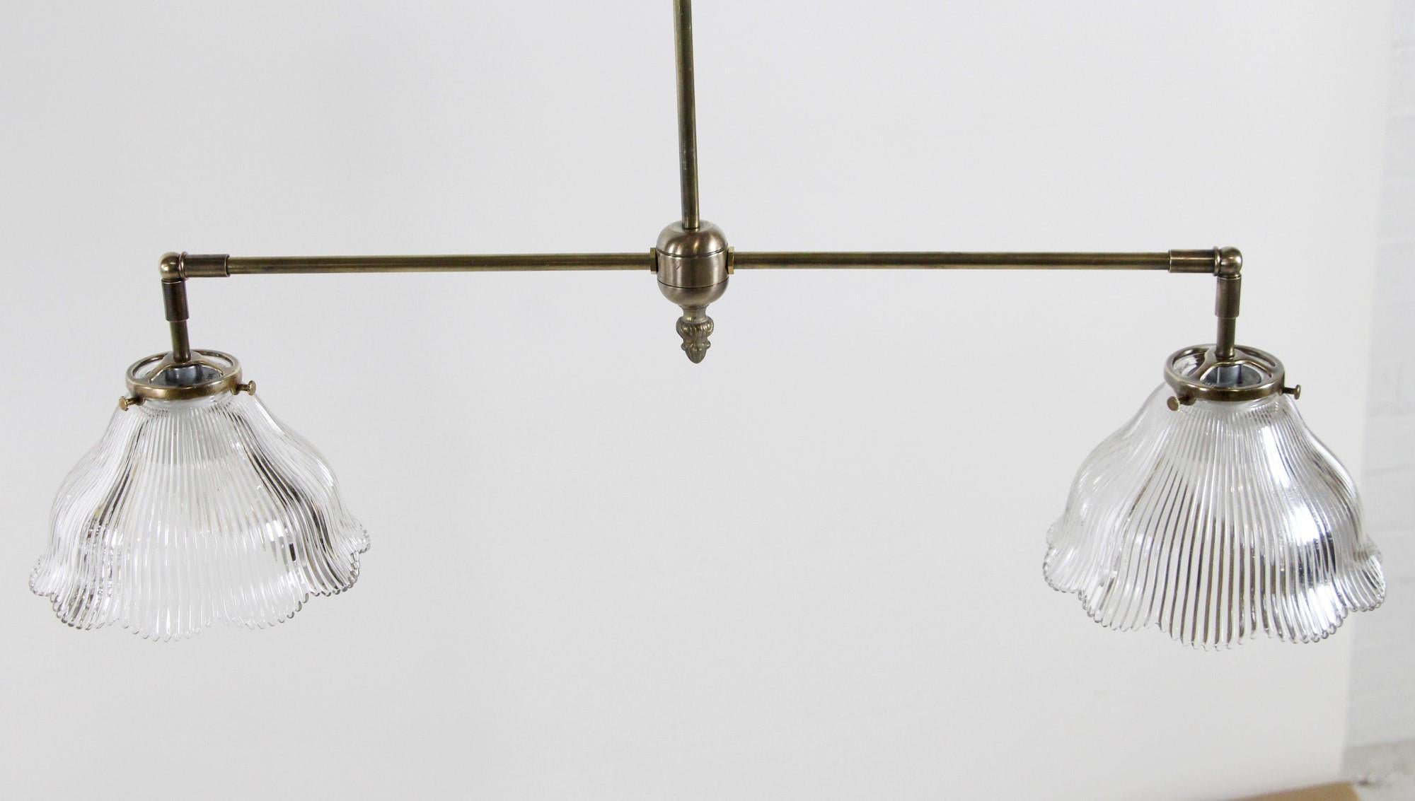 Lampe suspendue de style industriel en laiton des années 2010, équipée de deux abat-jours en verre prismatique à volutes, transparent et antique. Cet article peut être vu dans notre établissement du 400 Gilligan St à Scranton, PA.